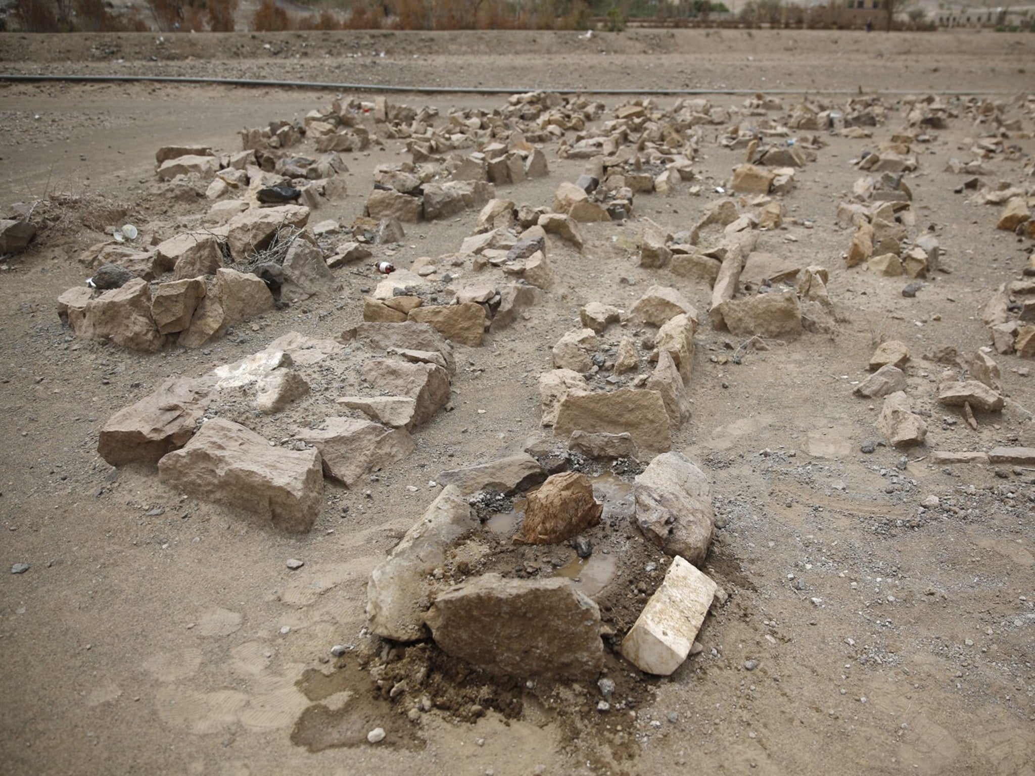 The watered grave of Udai Faisal, who died of severe acute malnutrition, is marked only by stones, at a graveyard in Hazyaz village on the southern outskirts of Sanaa, in March