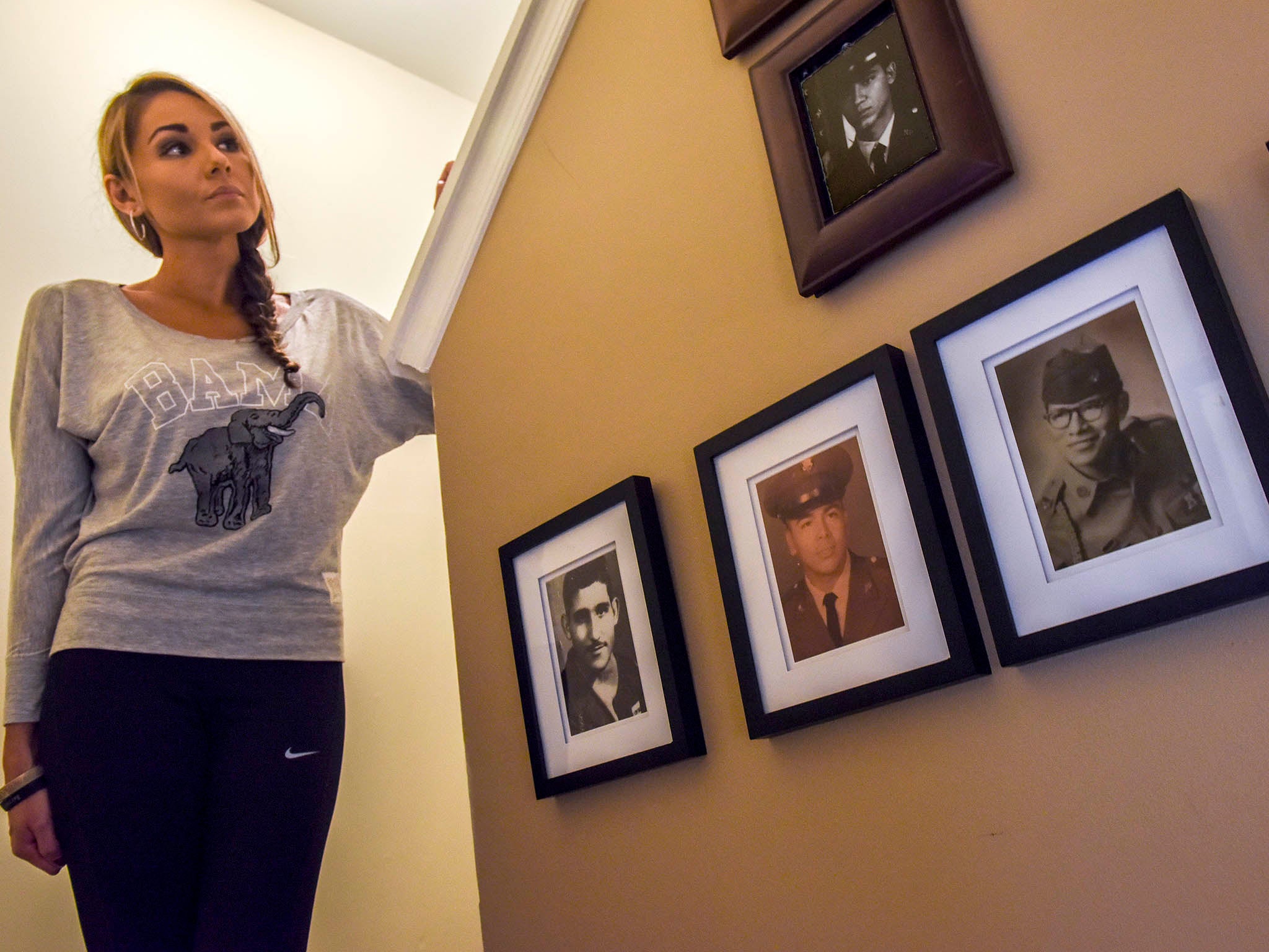 &#13;
Alyssa Bermudez has a gallery of photos of her family’s military service on a wall in her home in Odenton, Maryland (Bill O’Leary)&#13;