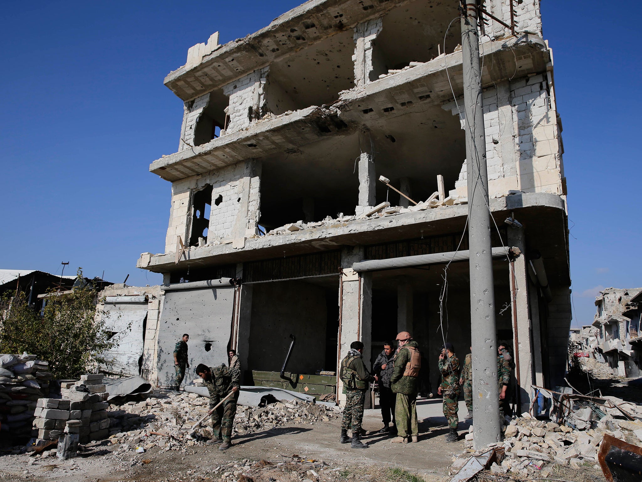 Russian and Syrian army soldiers gather at the last checkpoint before the front line with rebels in Karam al-Tarab, east of Aleppo