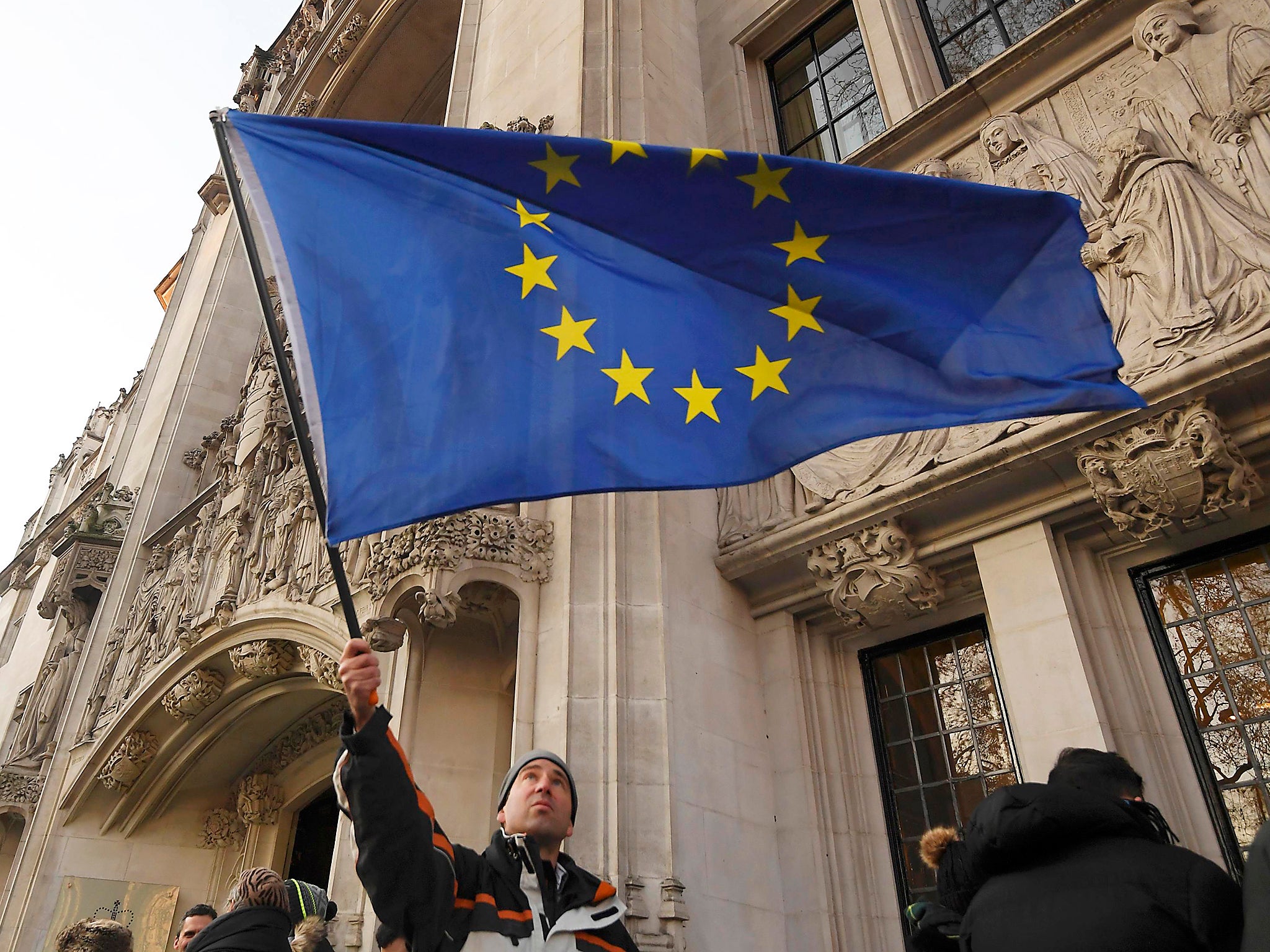 A man flies the EU flag outside the UK Supreme Court on Parliament Square