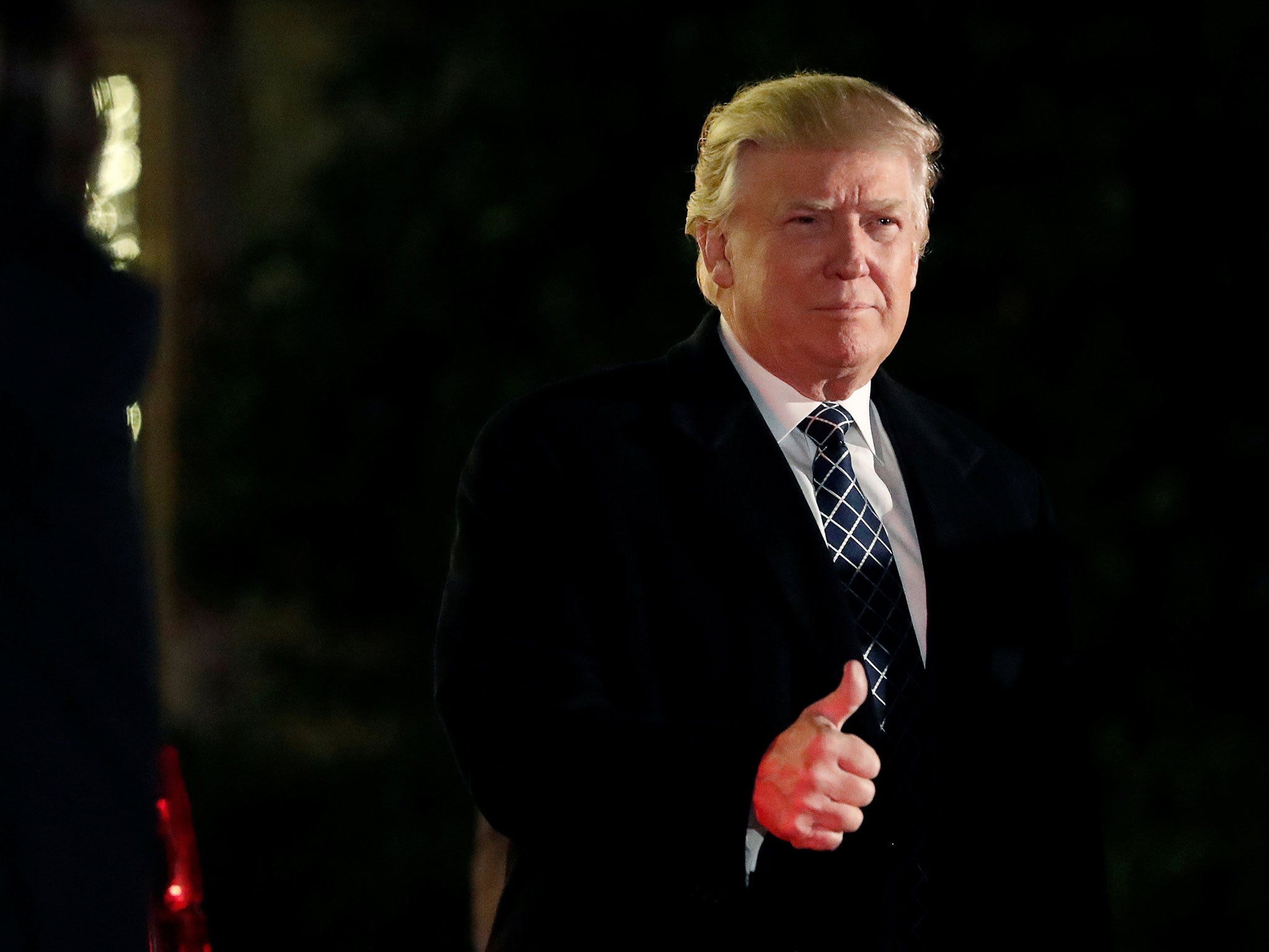 President-elect Donald Trump gives a thumbs up to the media as he arrives at a costume party in New York