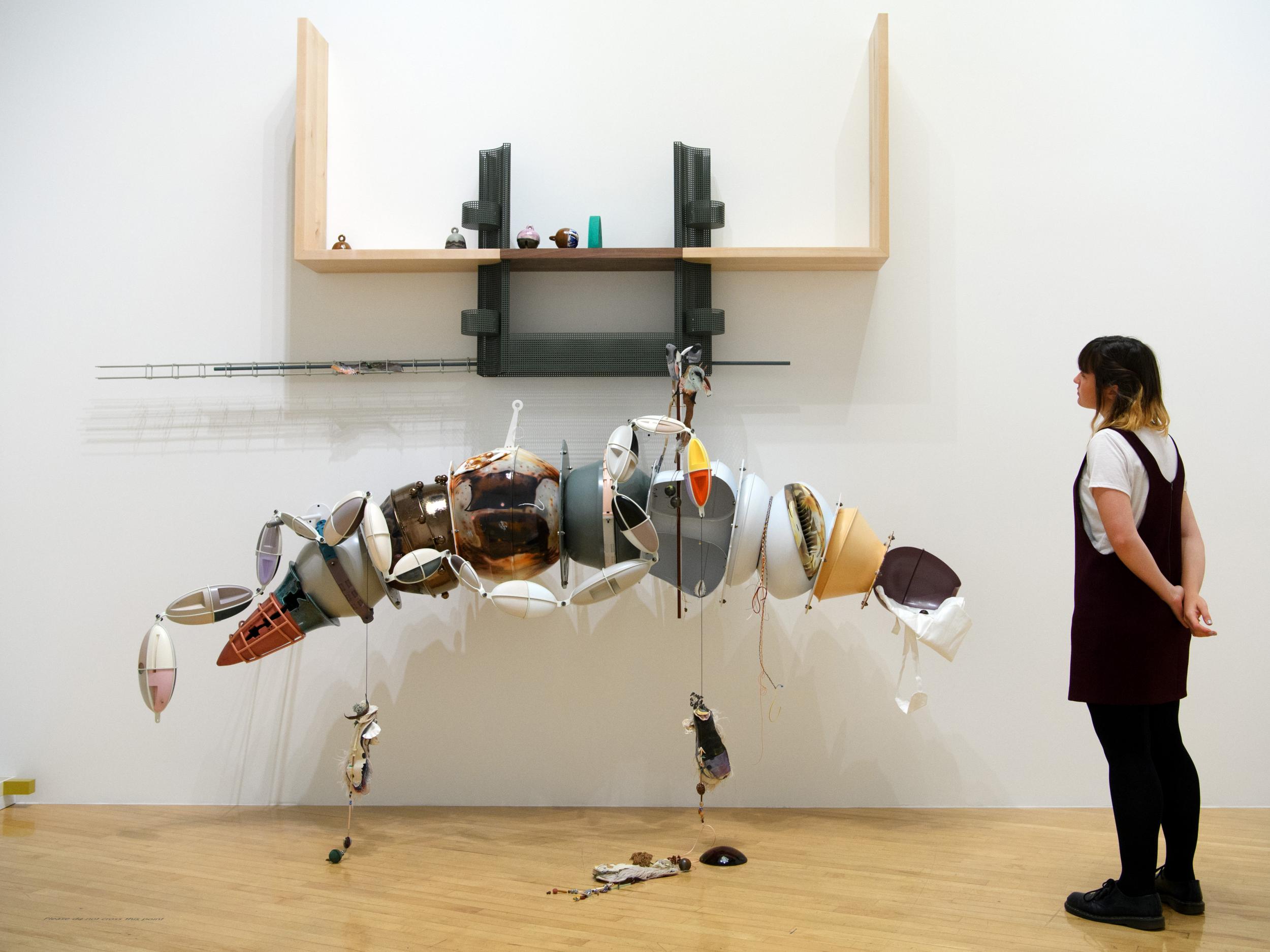 A member of staff poses next to Helen Marten's Turner Prize-winning installation at the Tate Britain