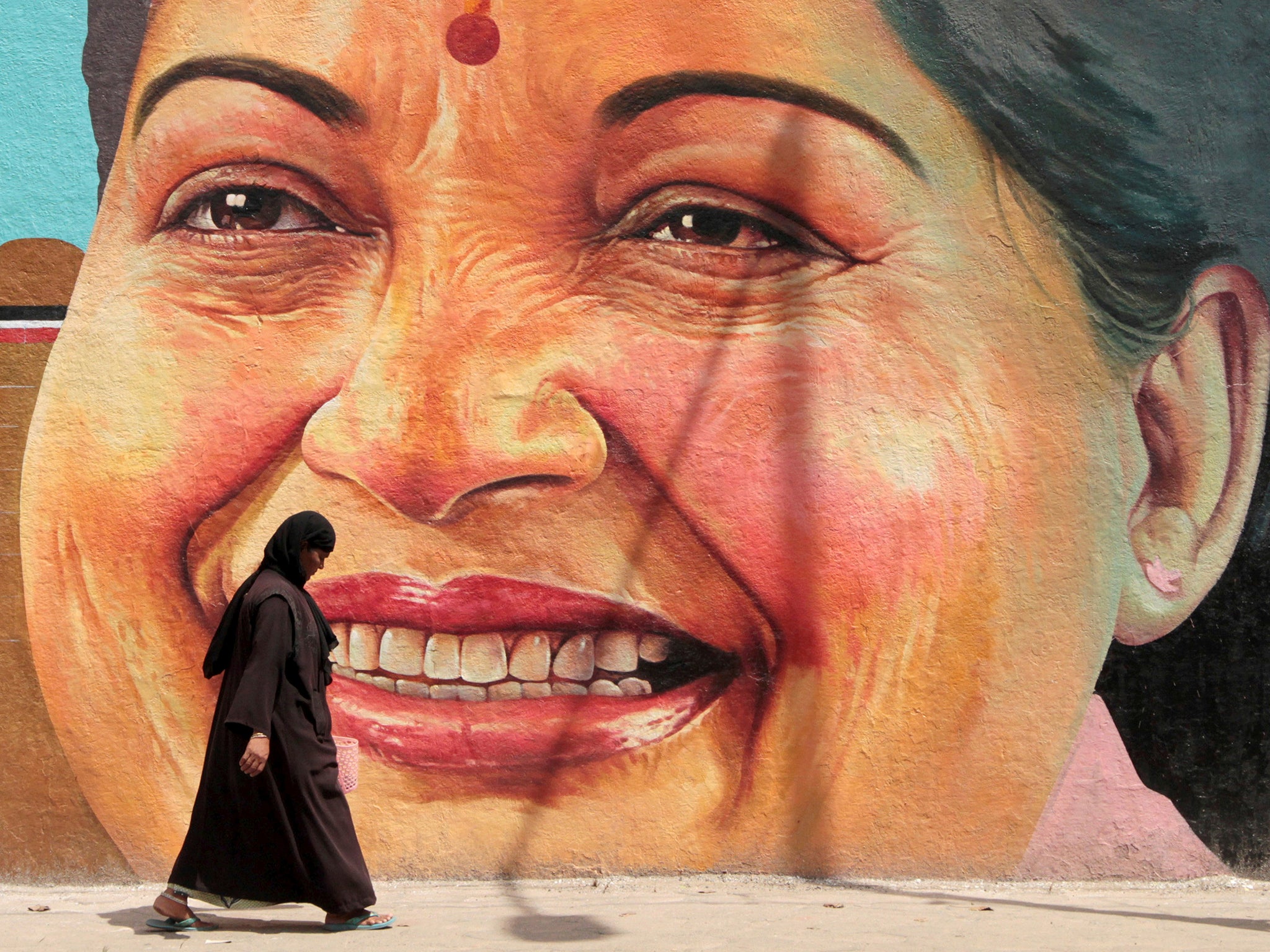 A woman walks past a portrait of Jayalalithaa in Chennai