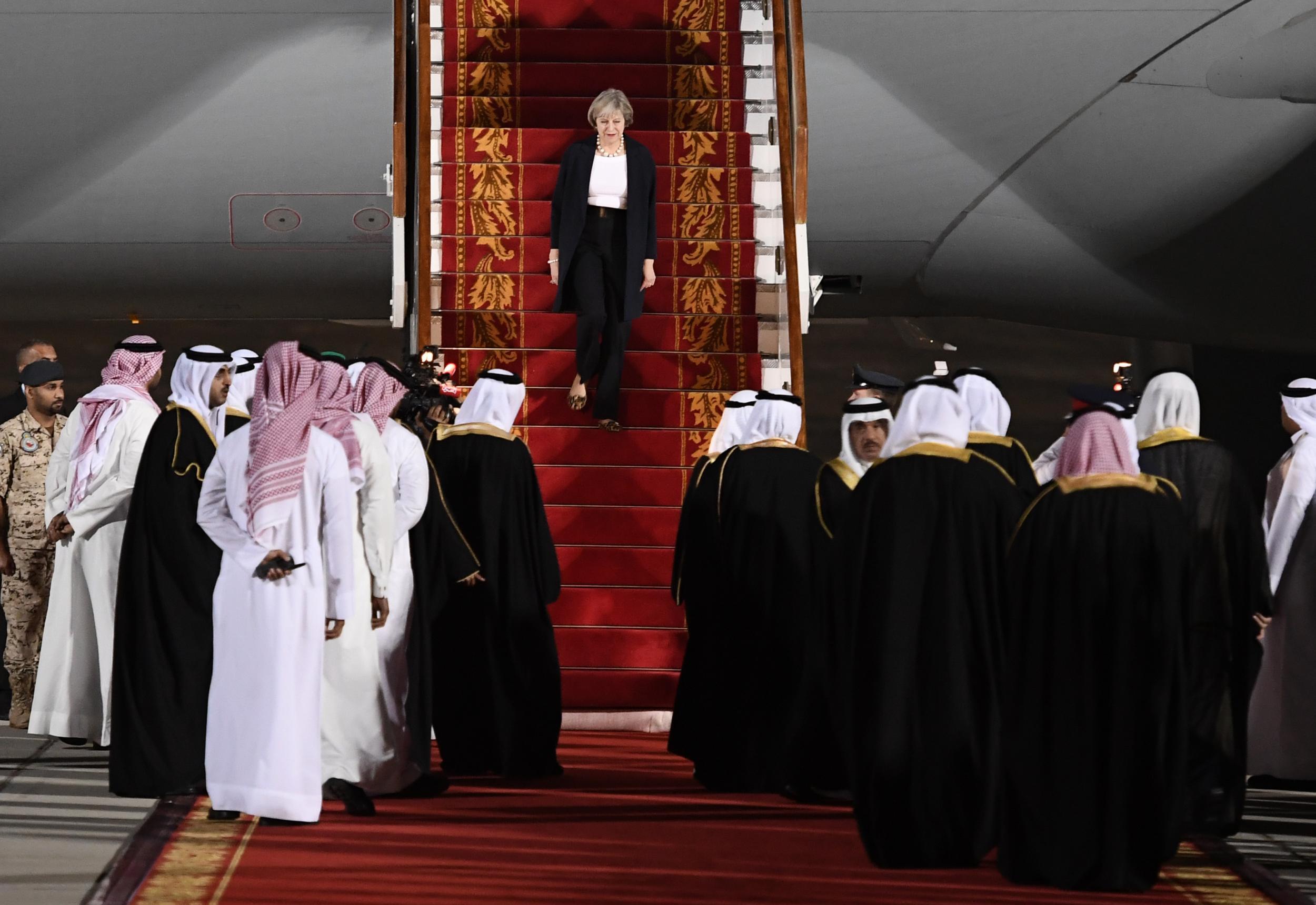 Theresa May descends the steps of her plane upon arrival at Sakhir Airbase in Bahrain