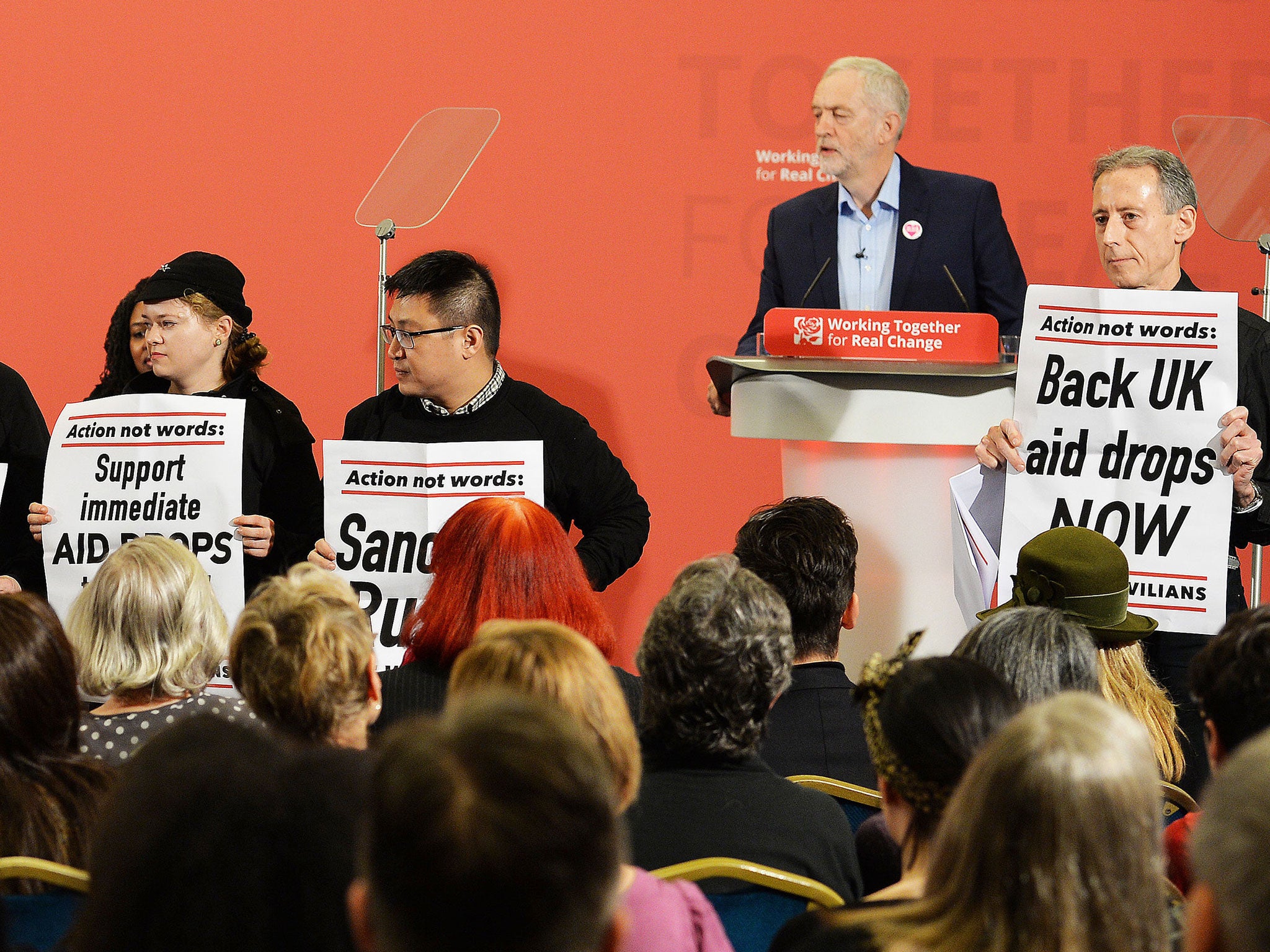 Peter Tatchell (right) leads protesters disrupting a speech by Jeremy Corbyn to demand more action in Aleppo, in London on 10 December