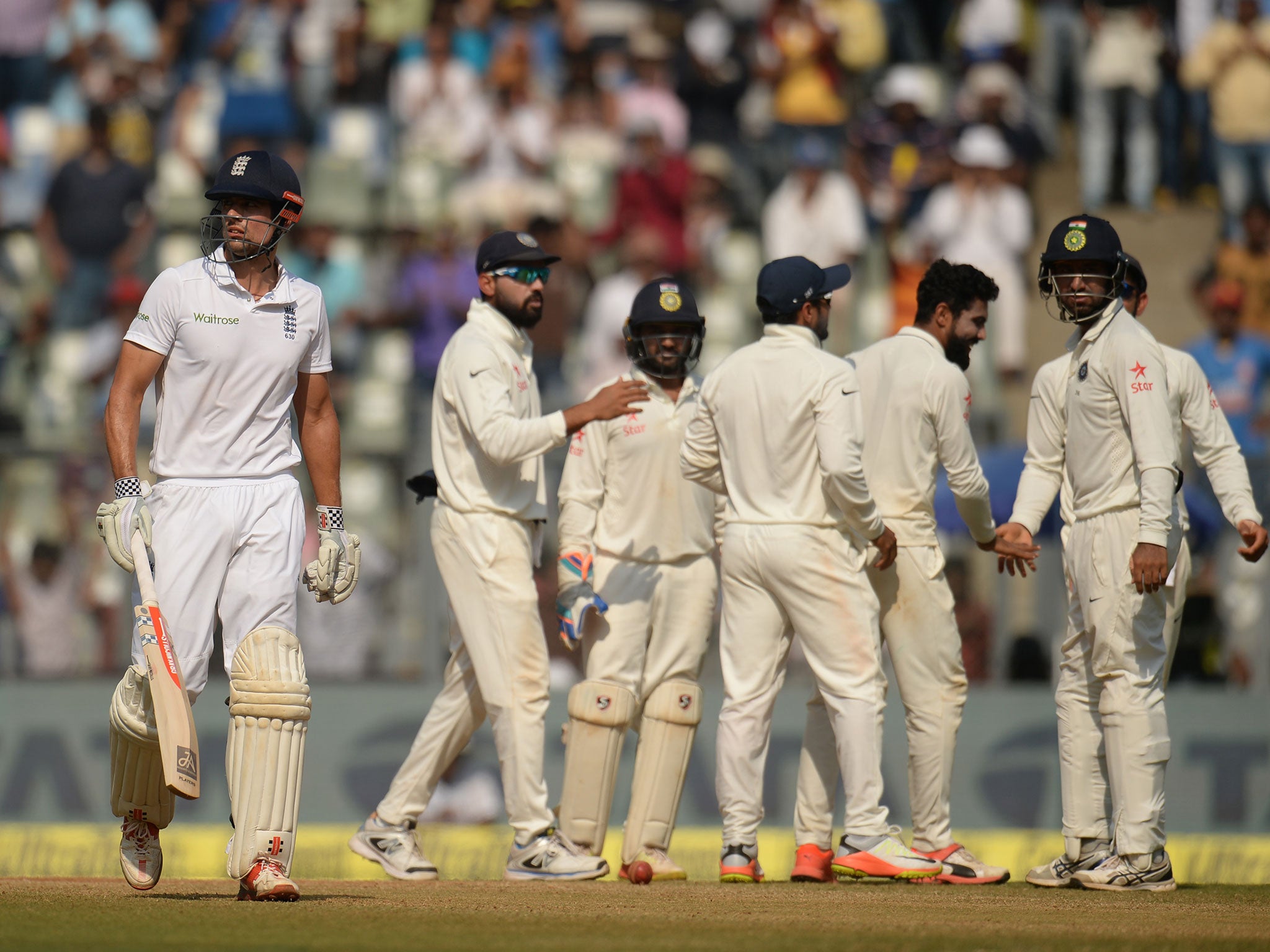 Alastair Cook leaves the crease after being dismissed during the fourth day of the fourth cricket test match at the Wankhede stadium