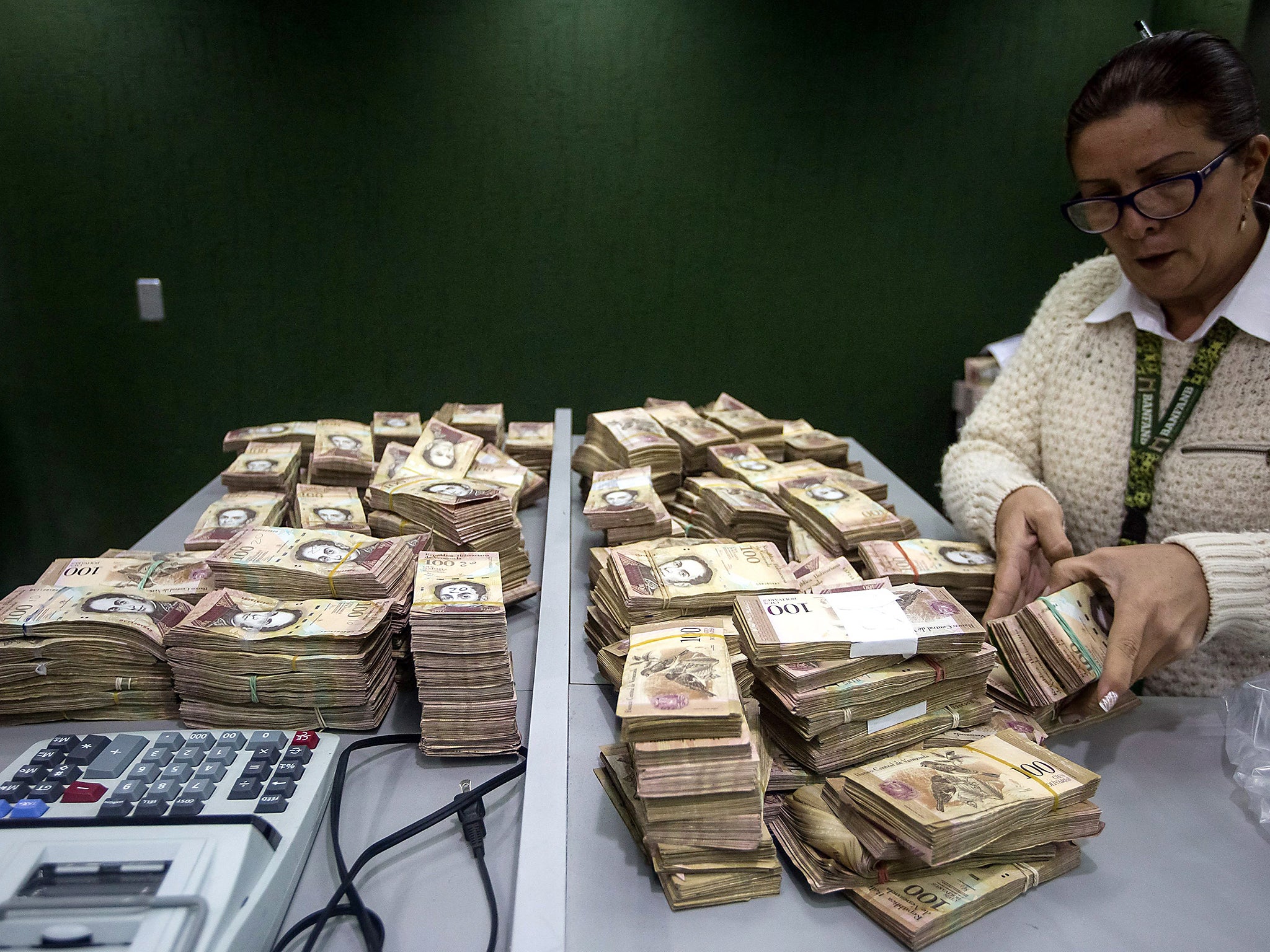 Bank workers count 100 Bolivares bills, in Caracas, Venezuela, amid the economic crisis EPA