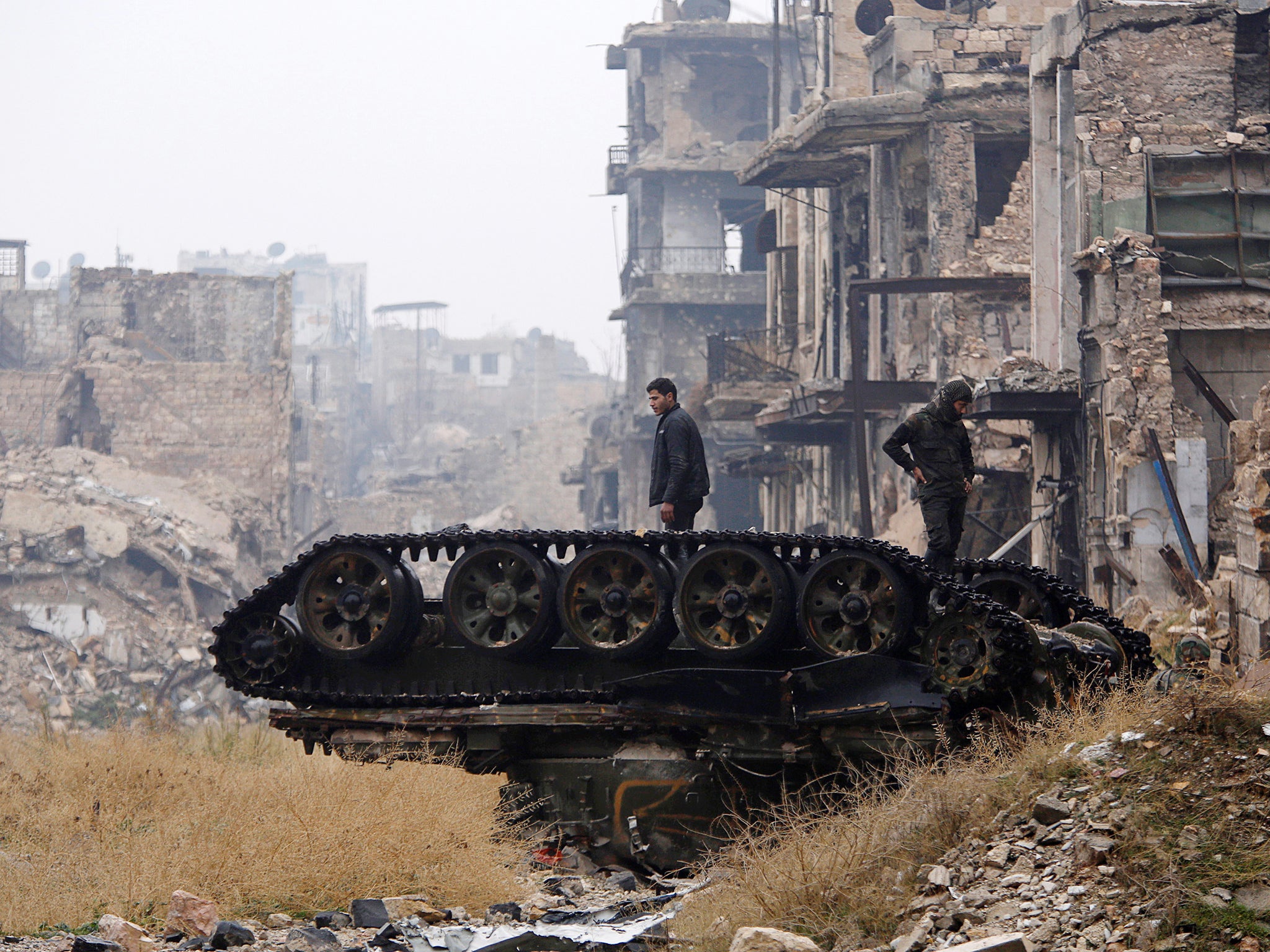 Forces loyal to Syria's President Bashar al-Assad stand atop a damaged tank near Umayyad mosque, in the government-controlled area of Aleppo, during a media tour, Syria