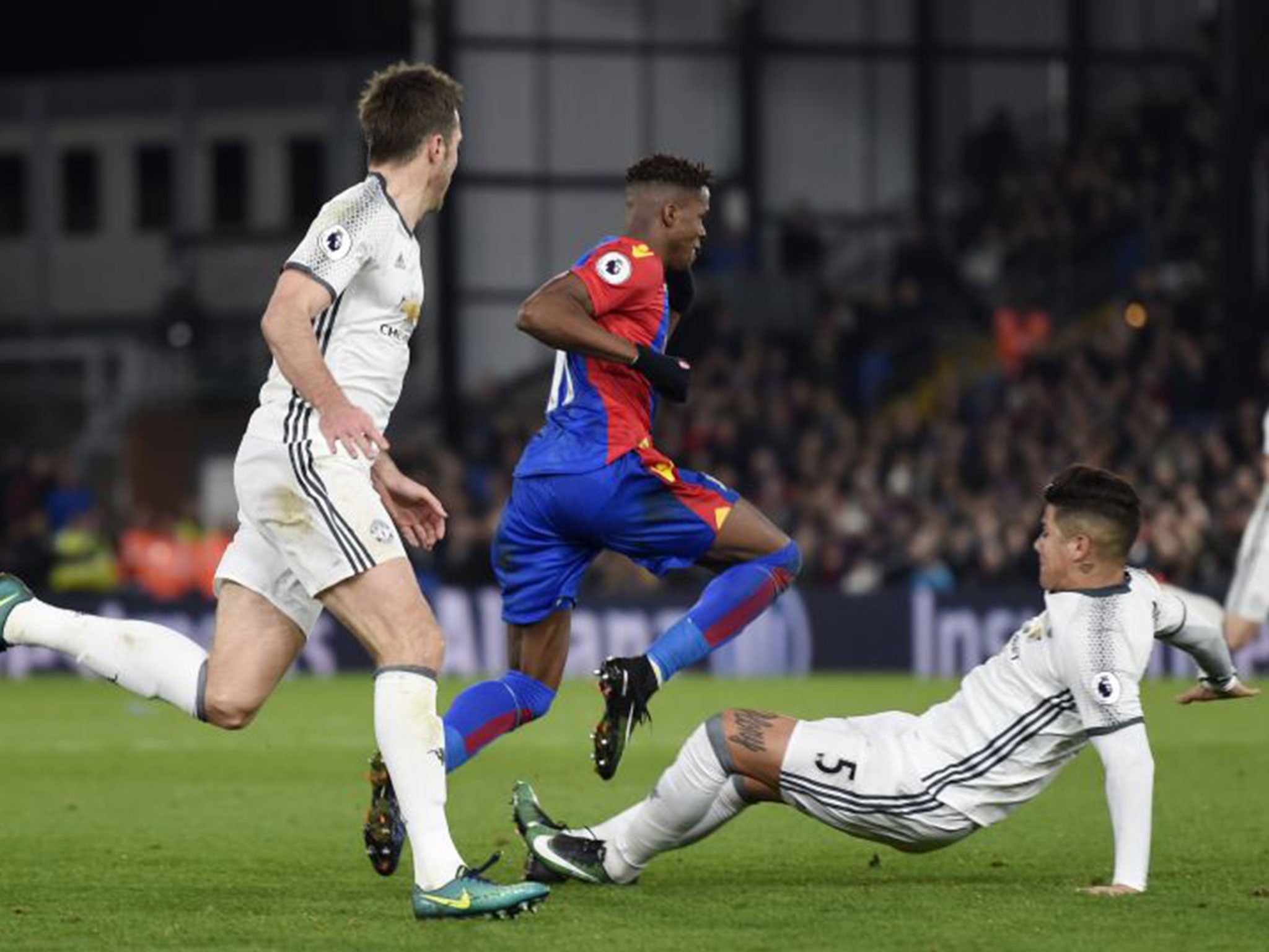 Marcos Rojo slides in on Wilfried Zaha with a two-footed tackle that Alan Pardew said deserved a red card