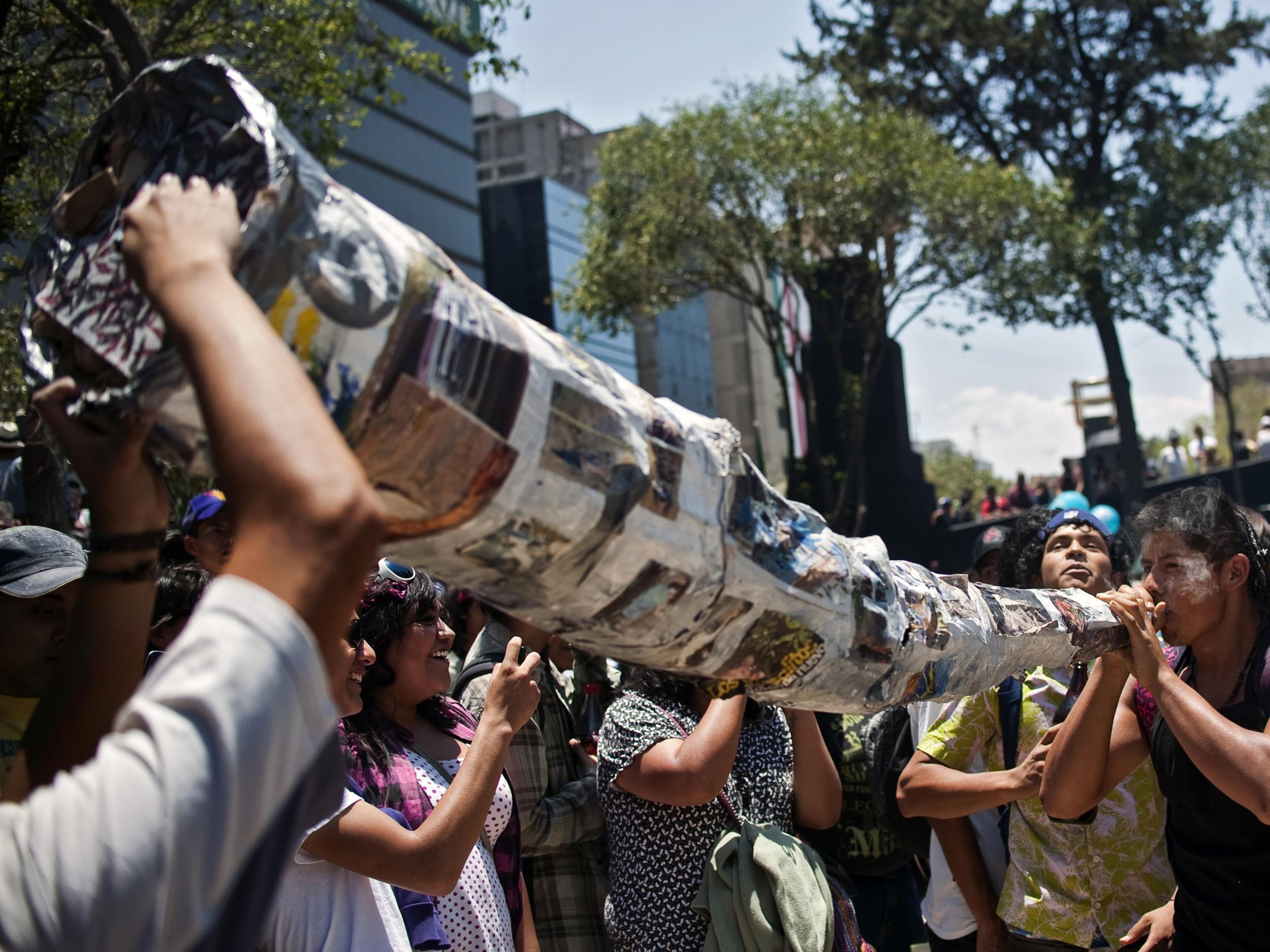 A man smoking a giant marijuana cigar during a demonstration in support of the drug's legalisation in Mexico City