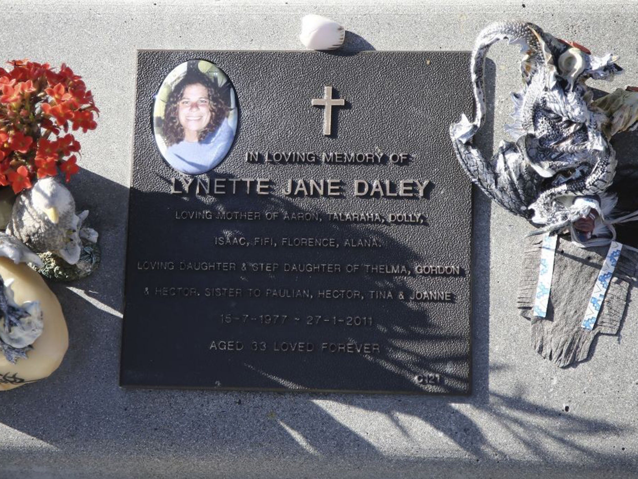 Flowers and mementos adorning the grave of the 33-year-old in Maclean, Australia