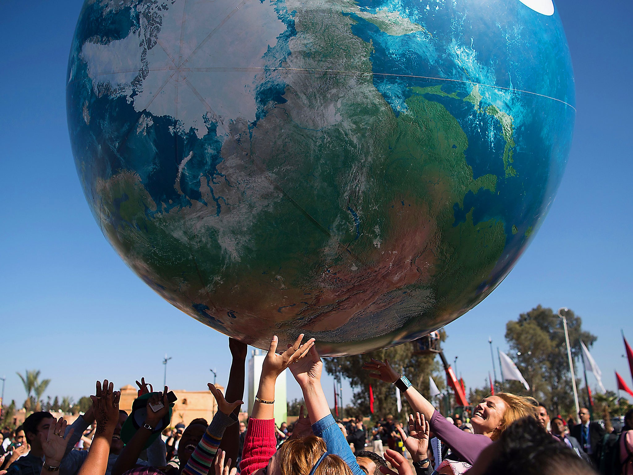 Members of International delegations play with a giant air globe ball outside the COP22 climate conference in Marrakesh