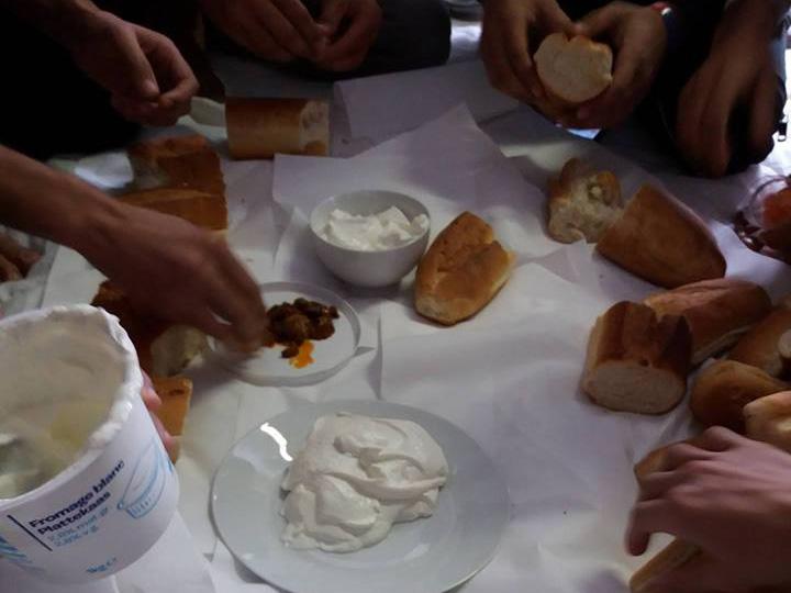 Young refugees in a CAO in Annemasse eating yoghurt and bread they were forced to buy because they say the food supplied was inadequate ( Shahajhan Khan)