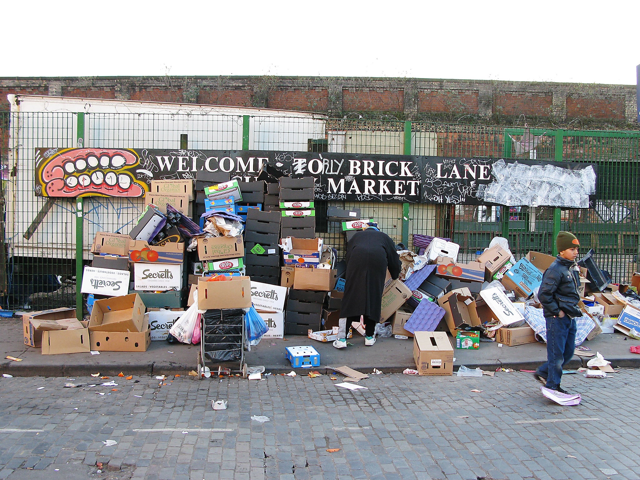 People looking through the rubbish for food they can use at Brick Lane market in London, England