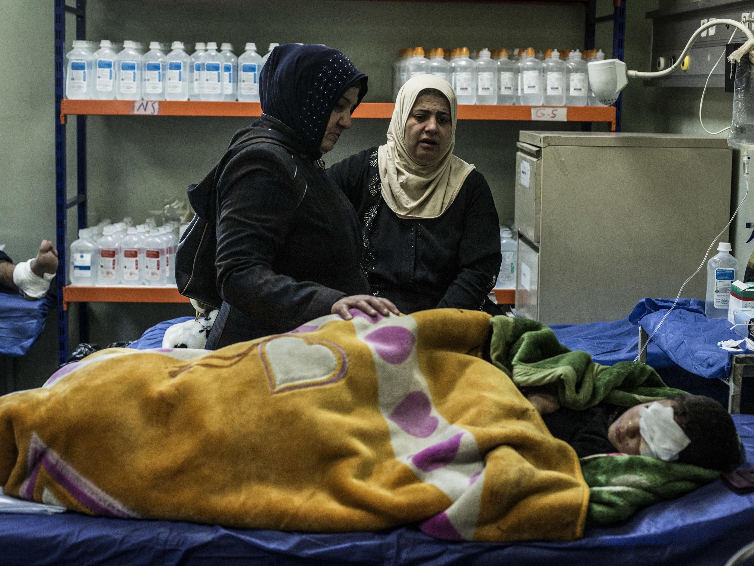 The mother and aunt of a boy wounded in a car bomb attack in the district of Gogjali in Mosul comfort him in a hospital in Irbil, Iraq