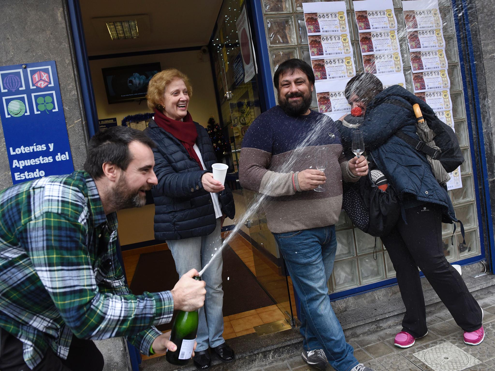 Spanish national lottery shop owners and lottery winners David Lobato (L) Jose Vadillo (2R) celebrate the sale of 50 first prize (66513) tickets in the Spanish Christmas lottery, "El Gordo", in the Basque village of Abadino