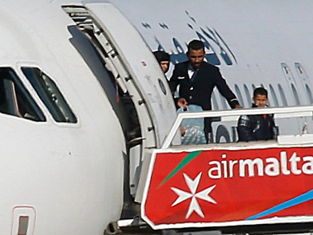 People disembark from a hijacked Libyan Afriqiyah Airways Airbus A320 on the runway at Malta Airport