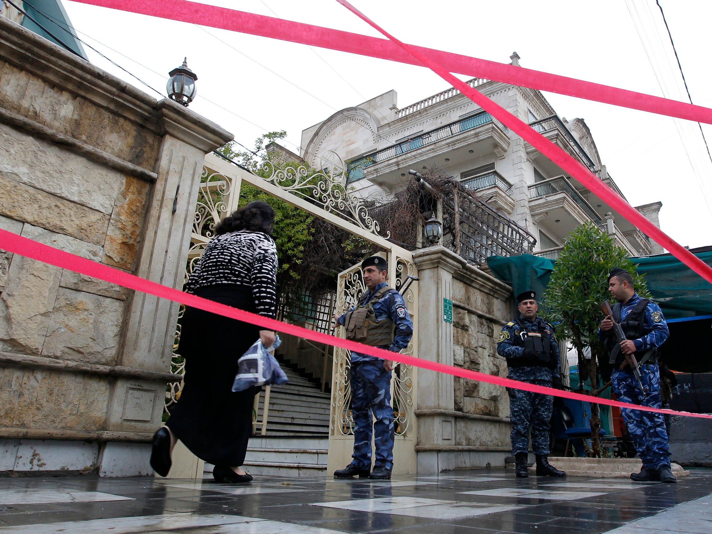 Iraqi policemen cordon off the Virgin Mary church in the Karrada neighbourhood of the capital Baghdad and check people as they arrive to attend a Christmas mass (Getty)