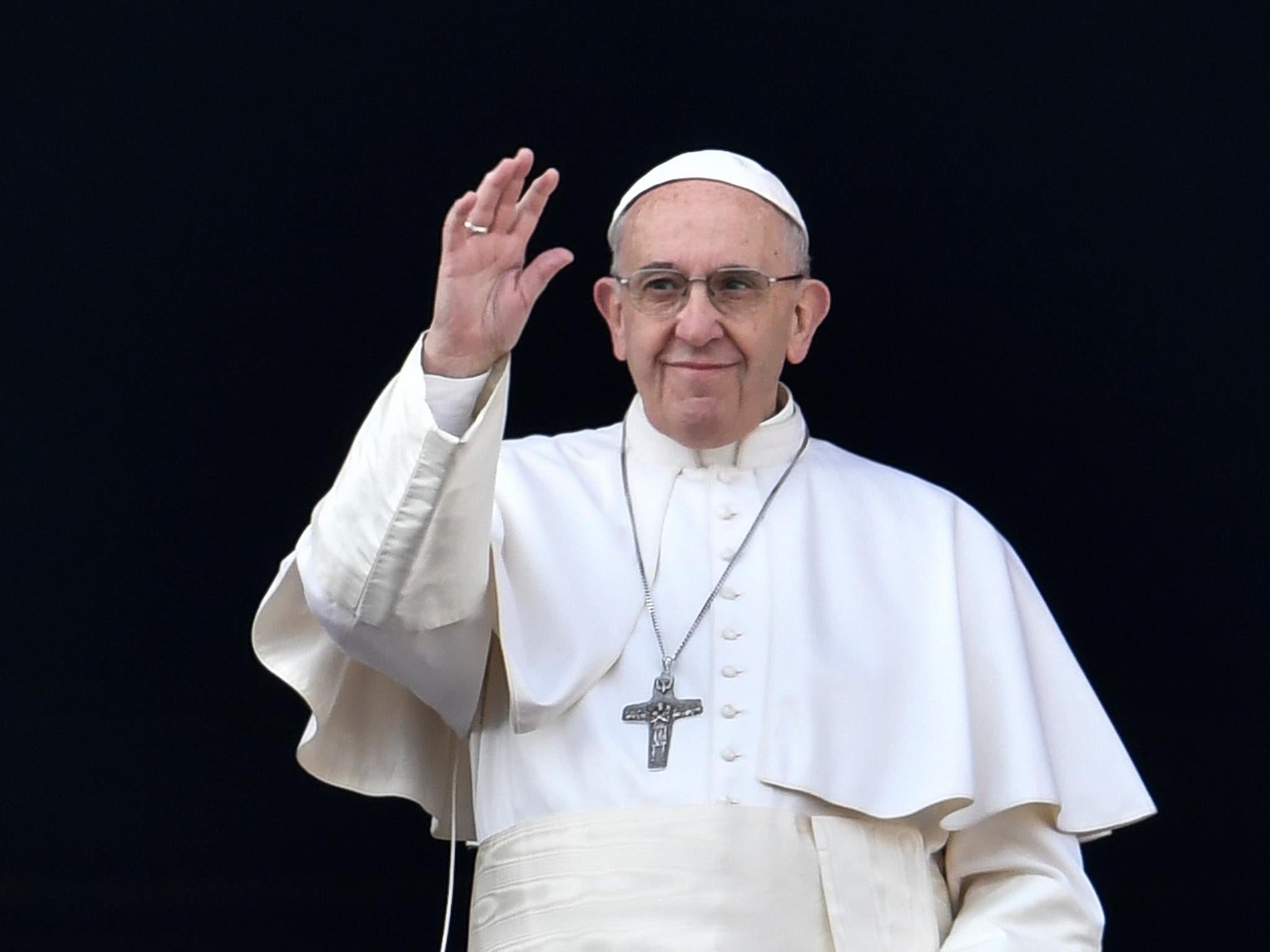 Pope Francis waves from the balcony of St Peter's basilica during the traditional 'Urbi et Orbi' Christmas message to the city and the world, on 25 December, 2016 at St Peter's square in the Vatican