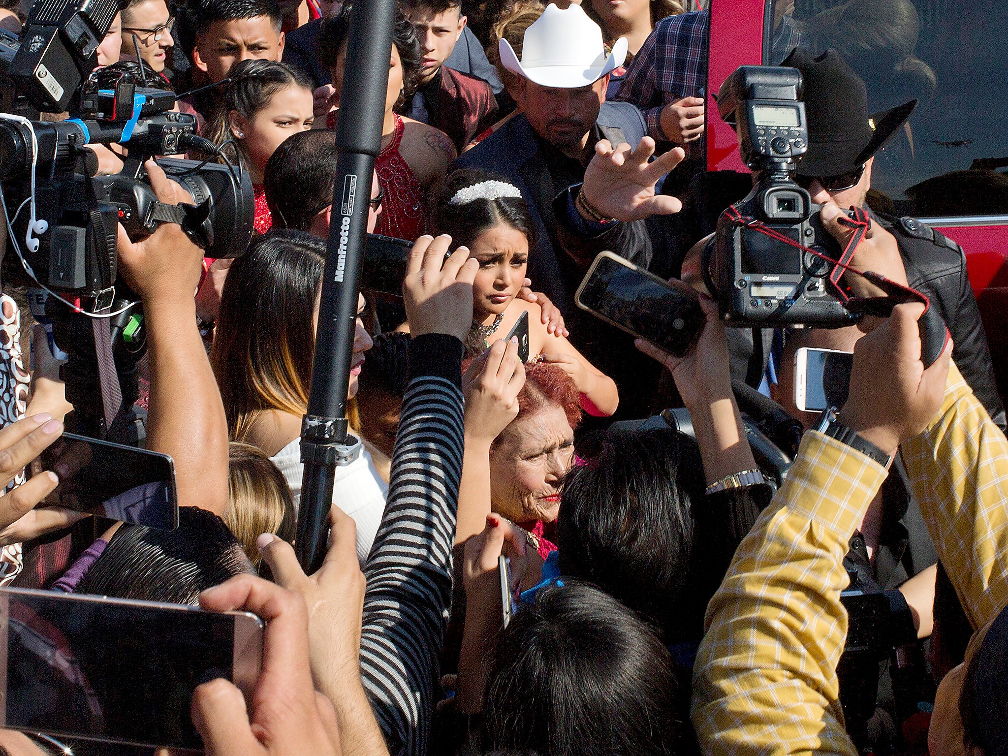 Rubi Ibarra arrives at the site of a Mass that was part of her 15th birthday party, surrounded by a horde of journalists, in the village of La Joya, San Luis Potosi State, Mexico