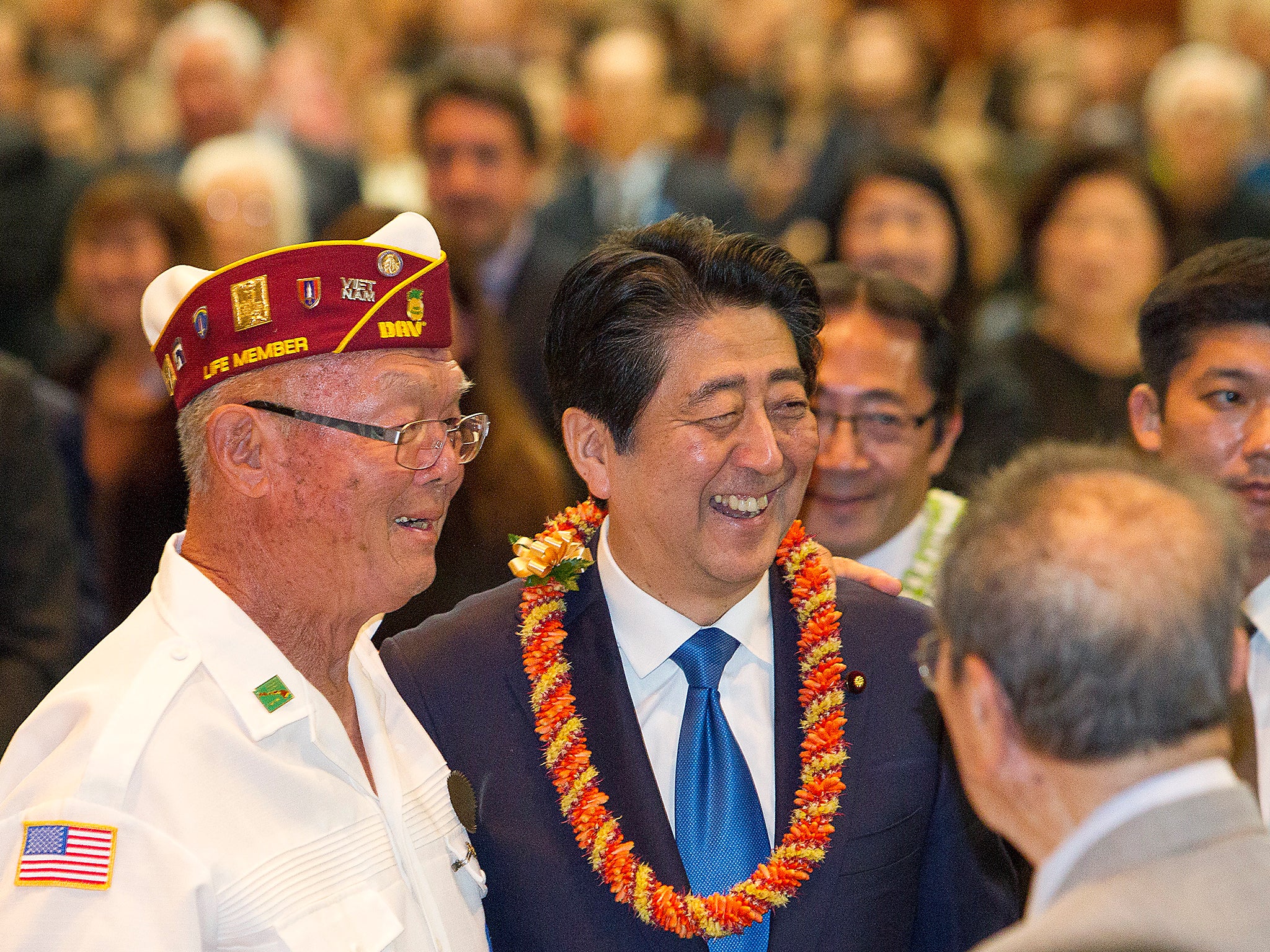 Japanese Prime Minister Shinzo Abe, center, greets guests at a dinner held in Abe's honour in Honolulu, Hawaii