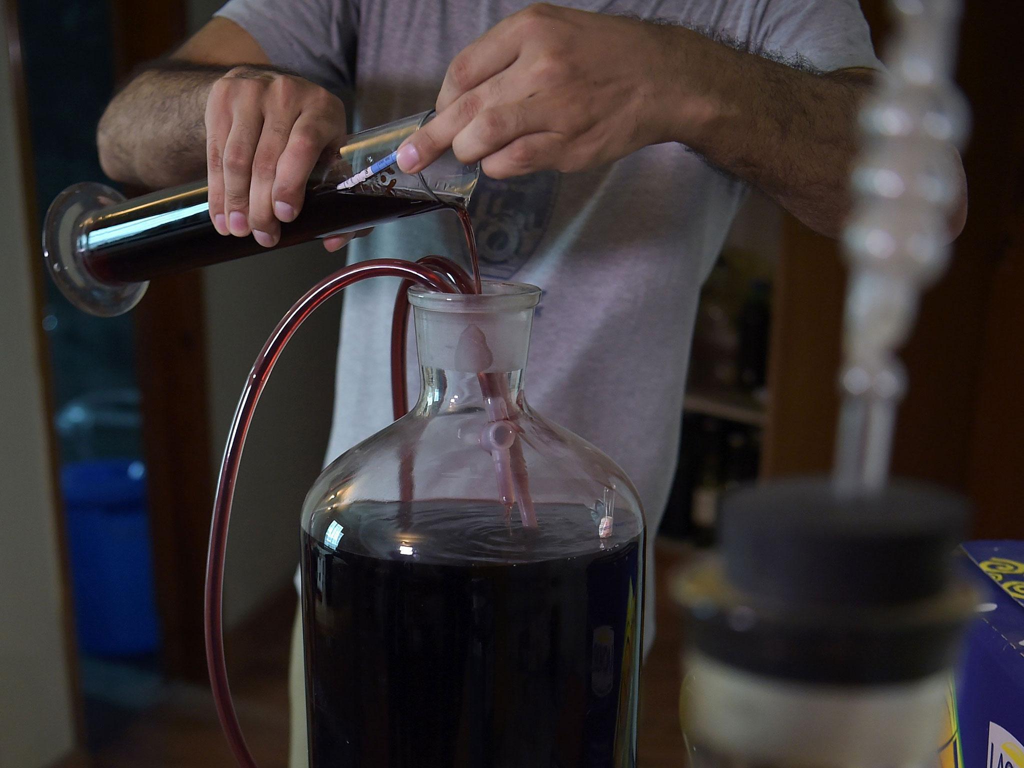 A Pakistani resident checks homemade wine bottles at his home in Islamabad