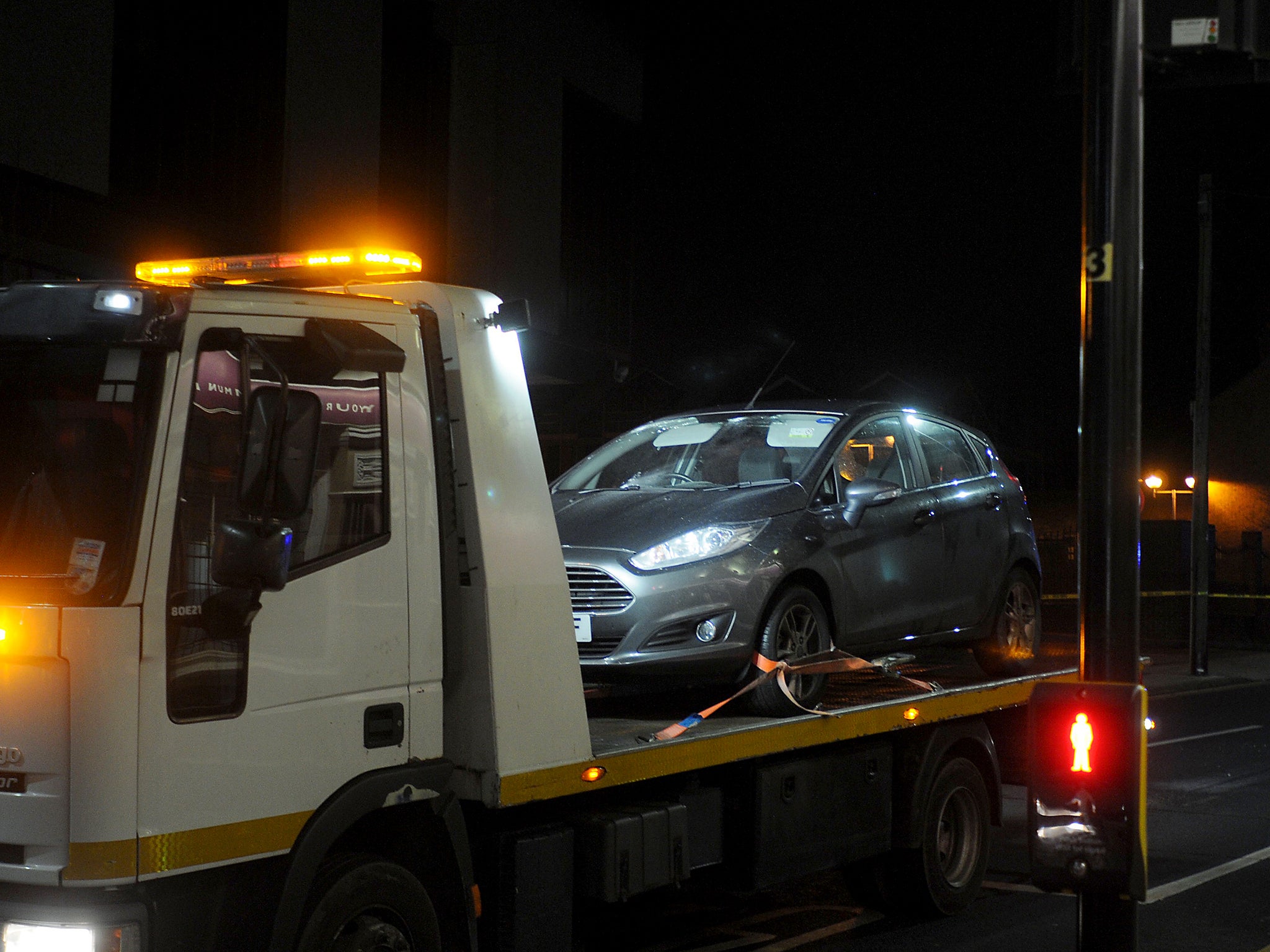 A small Ford Hatchback is loaded onto a removal truck at the scene of the shooting in West Bromwich town centre after a man died after being shot in the head while sitting in a vehicle