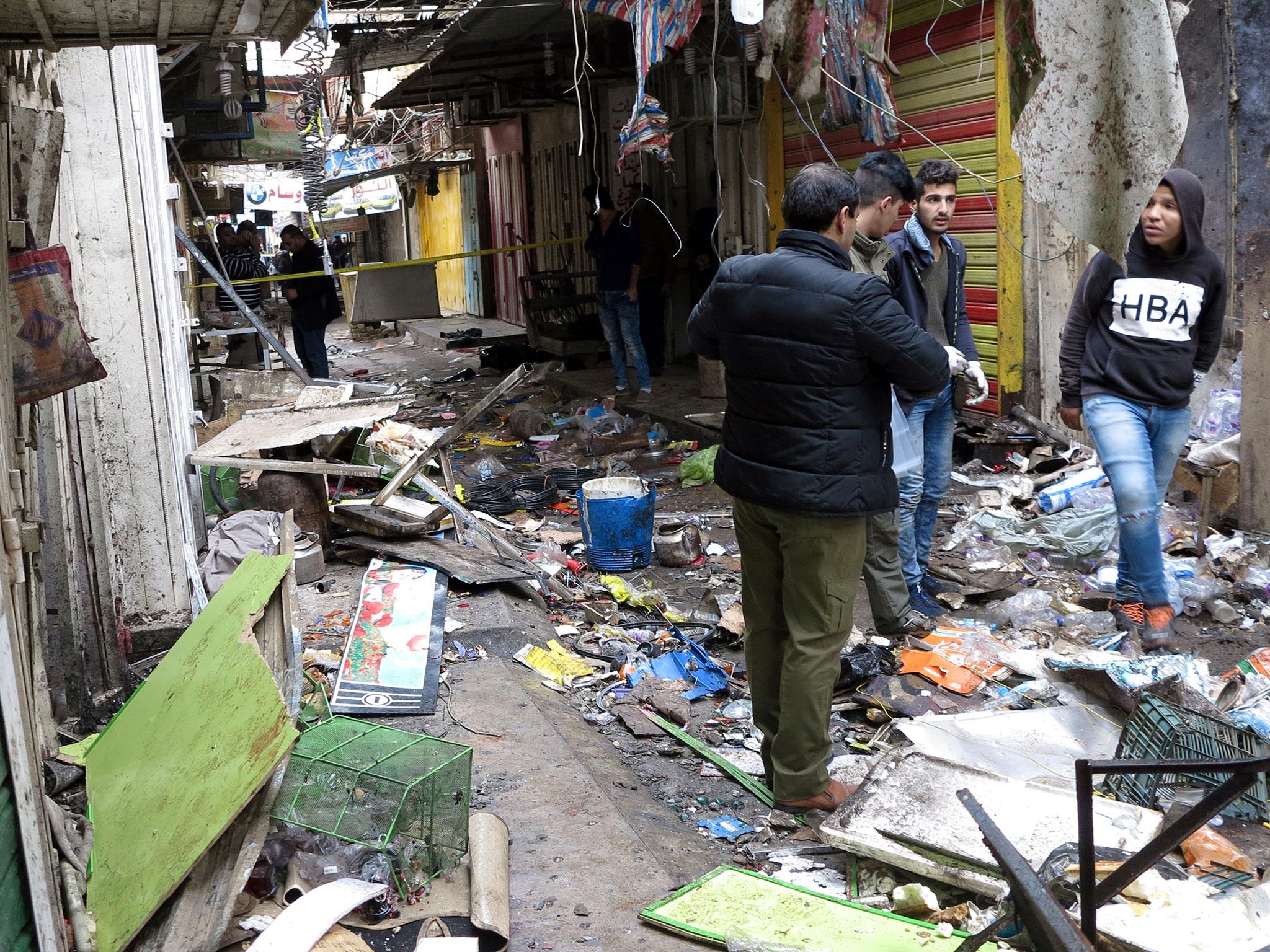 Iraqi security forces inspecting the bomb attack site at the market