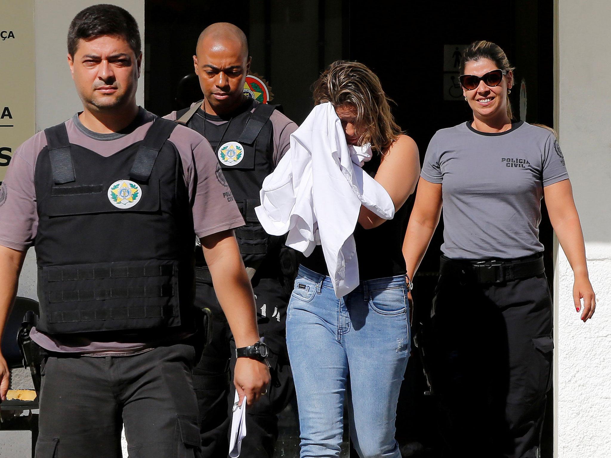 Francoise Souza Oliveira, 40, wife of Greek Ambassador for Brazil Kyriakos Amiridis, is escorted by police officers as she is transferred from the police station to a jail in Belford Roxo, Brazil, 31 December, 2016