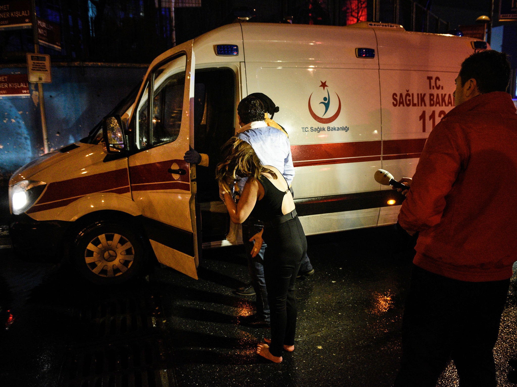 People talk to medics in an ambulance near the scene of an attack in Istanbul on 1 January 2017