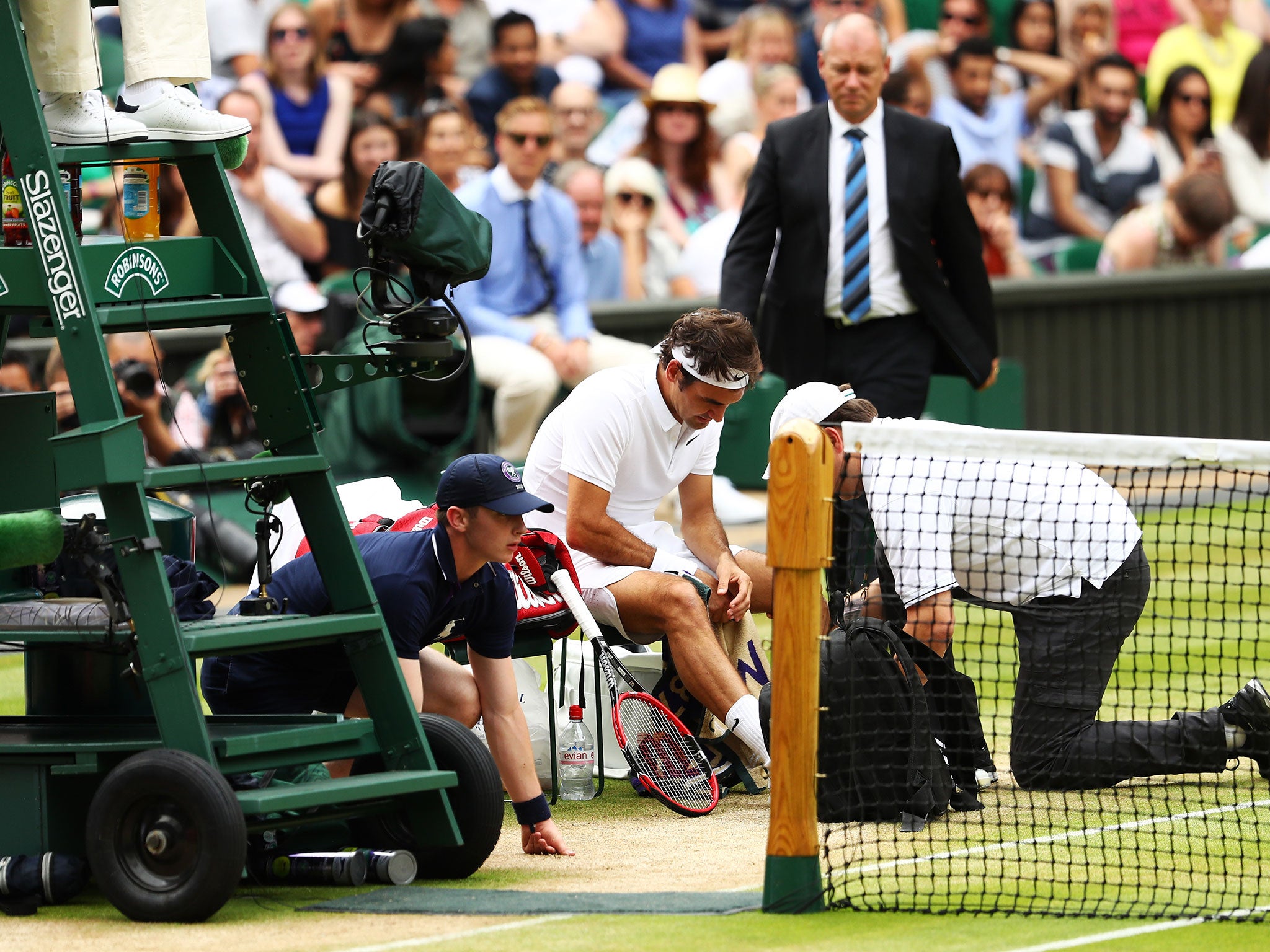 Federer receives treatment after suffering a heavy fall at Wimbledon
