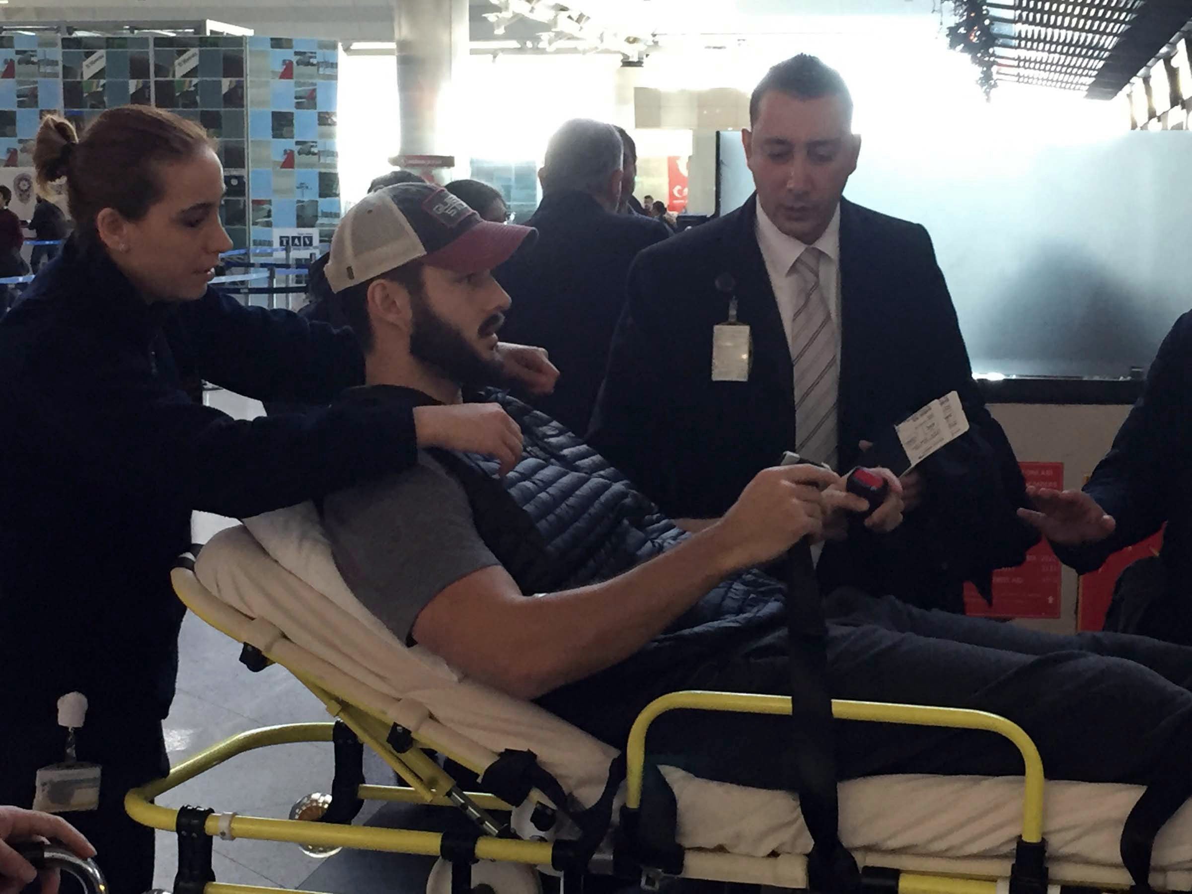 People carry William Jacob Raak, 35, a Delaware business owner originally from Pennsylvania on a stretcher as he returns back home at Ataturk Airport, in Istanbul