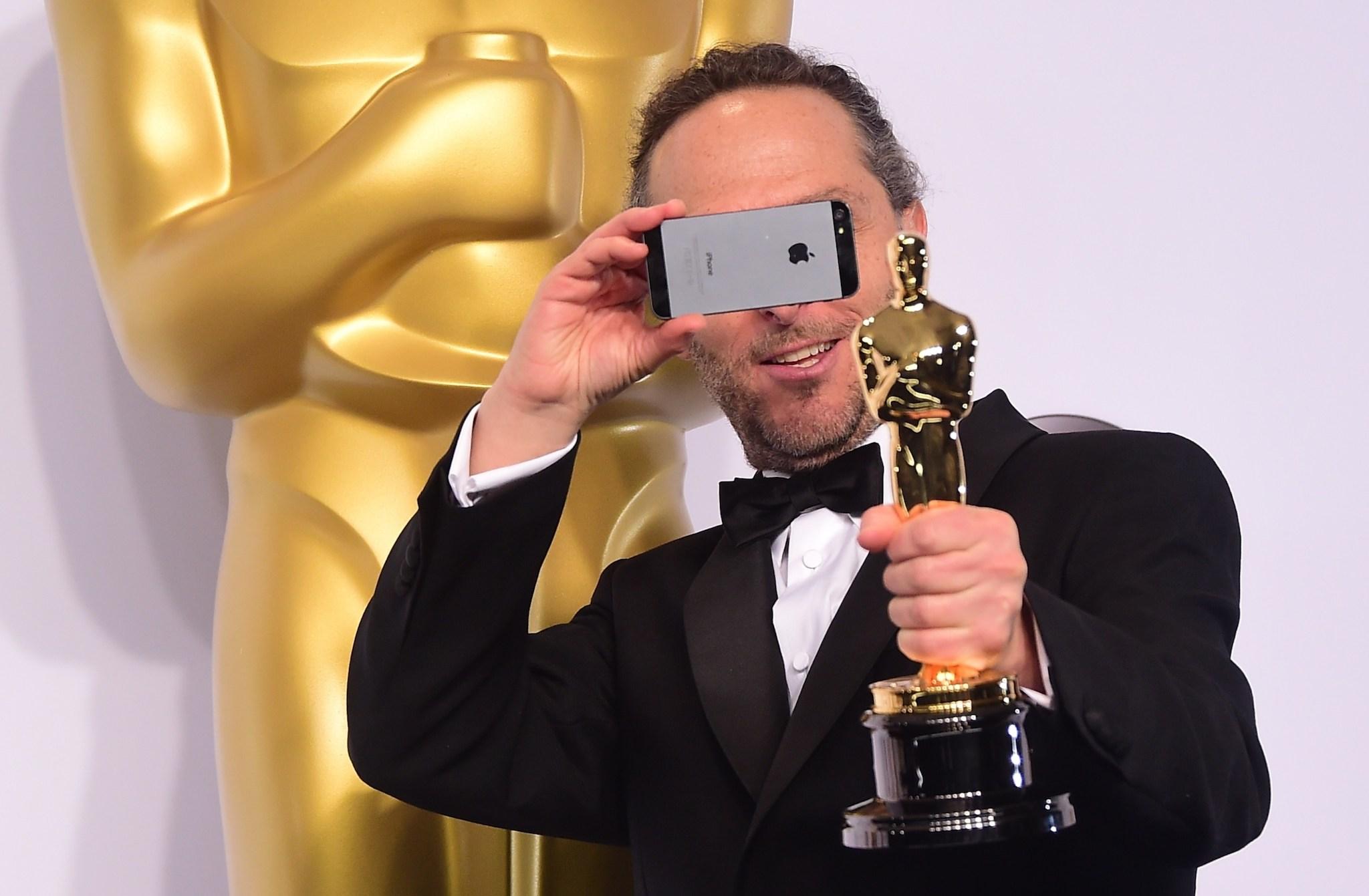 Emmanuel Lubezki, winner for the Best Cinematography Award for 'Birdman' takes a photo in the press room during the 87th Oscars on February 22, 2015 in Hollywood, California