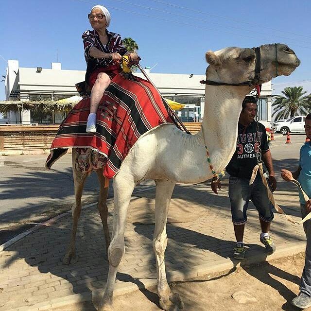 Baba Lena the travelling Russian granny riding a camel in Israel