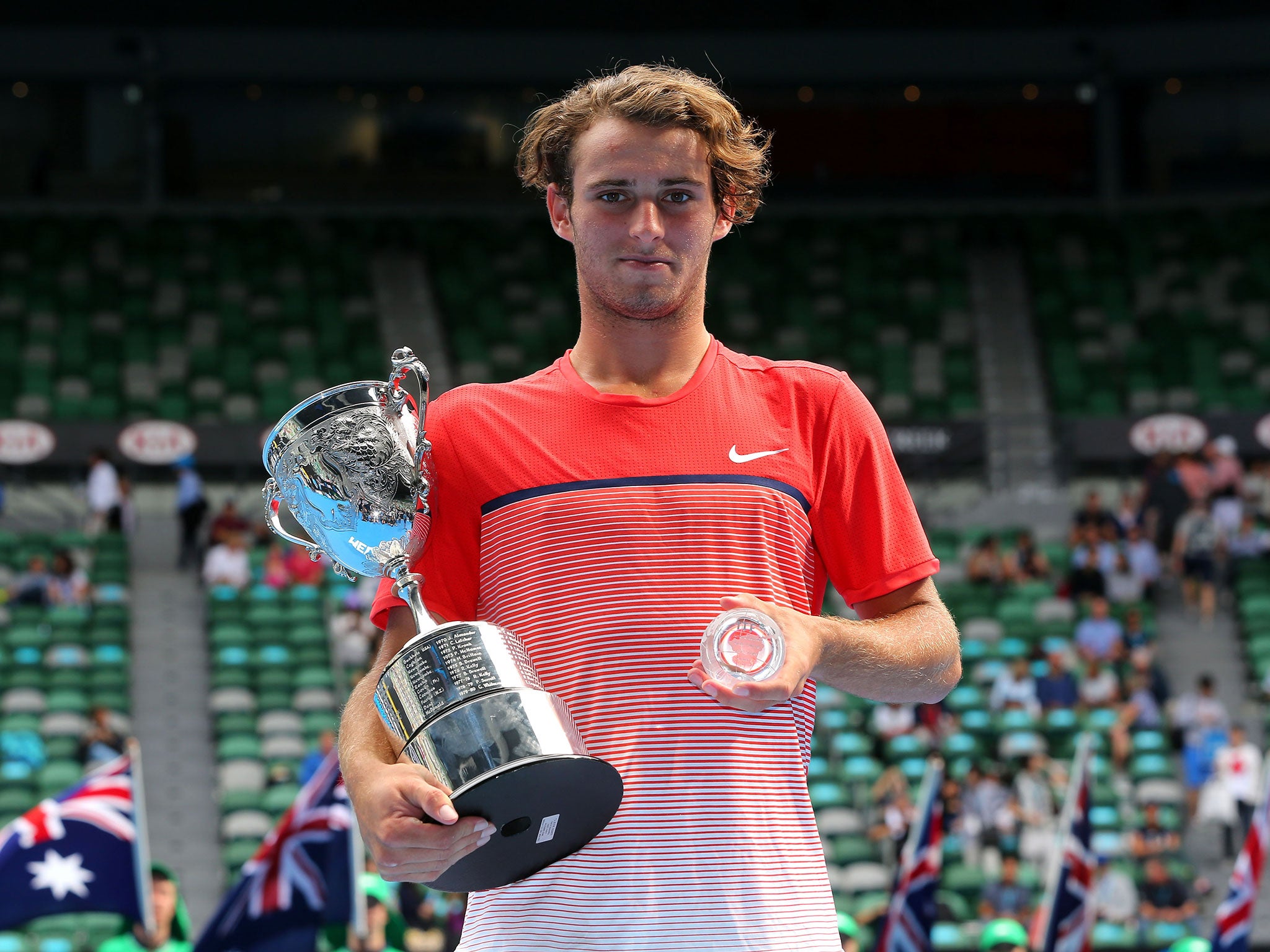 Oliver Anderson poses with the championship trophy after winning his Junior Boys' Singles Final match against Jurabeck Karimov of Uzbekistan