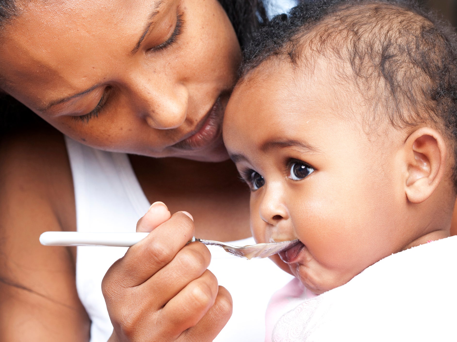 A five-month-old baby being fed with a spoon. New guidelines suggest babies should be given peanut-based foods early