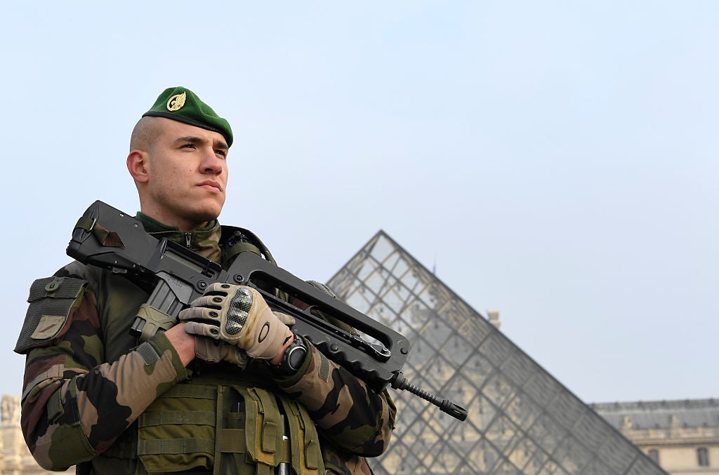 A soldier stands guard at the entrance of the Louvre museum in Paris