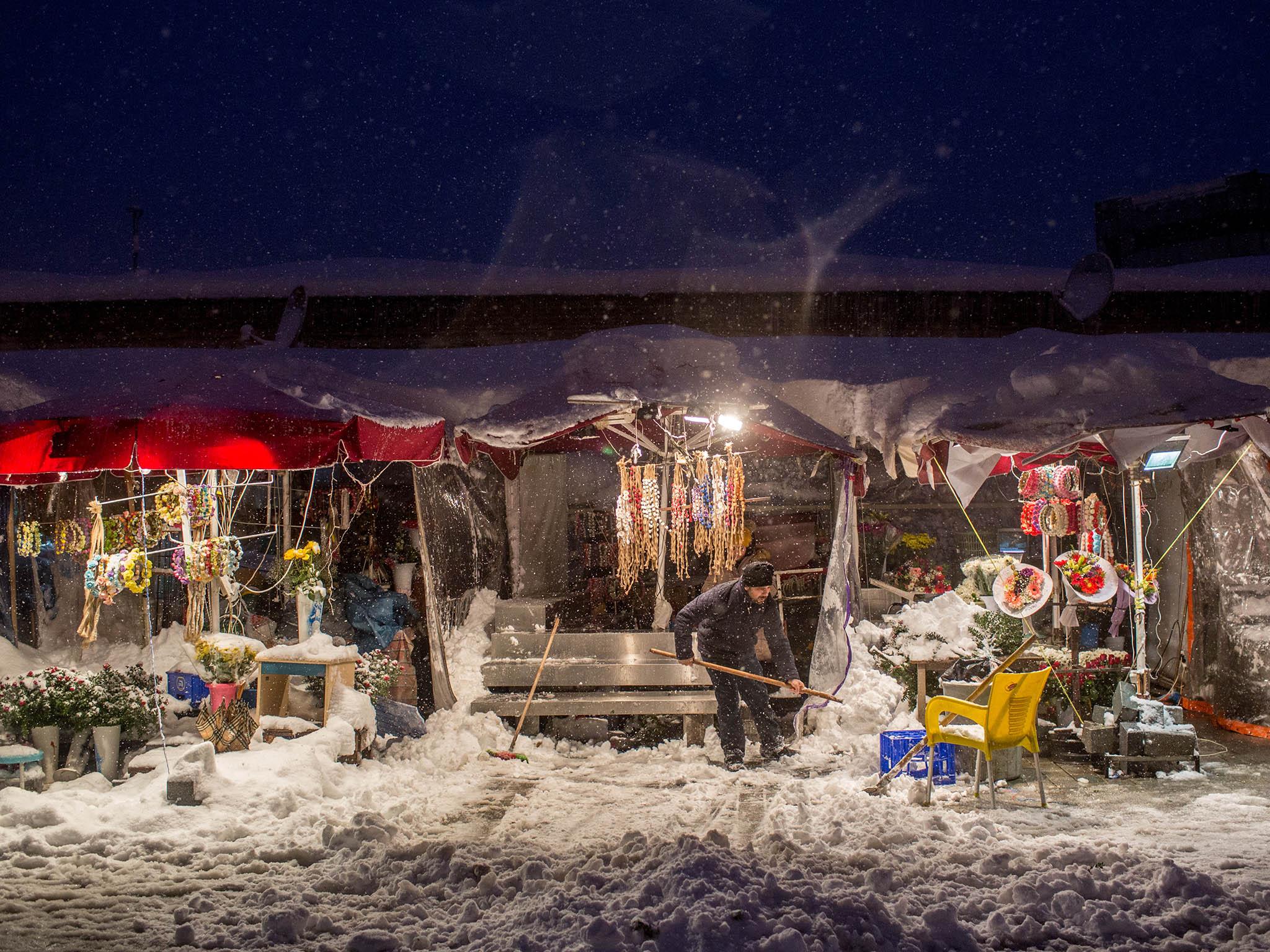 Shopkeepers like this one in Taksim Square were busy clearing up the snow outside their stalls