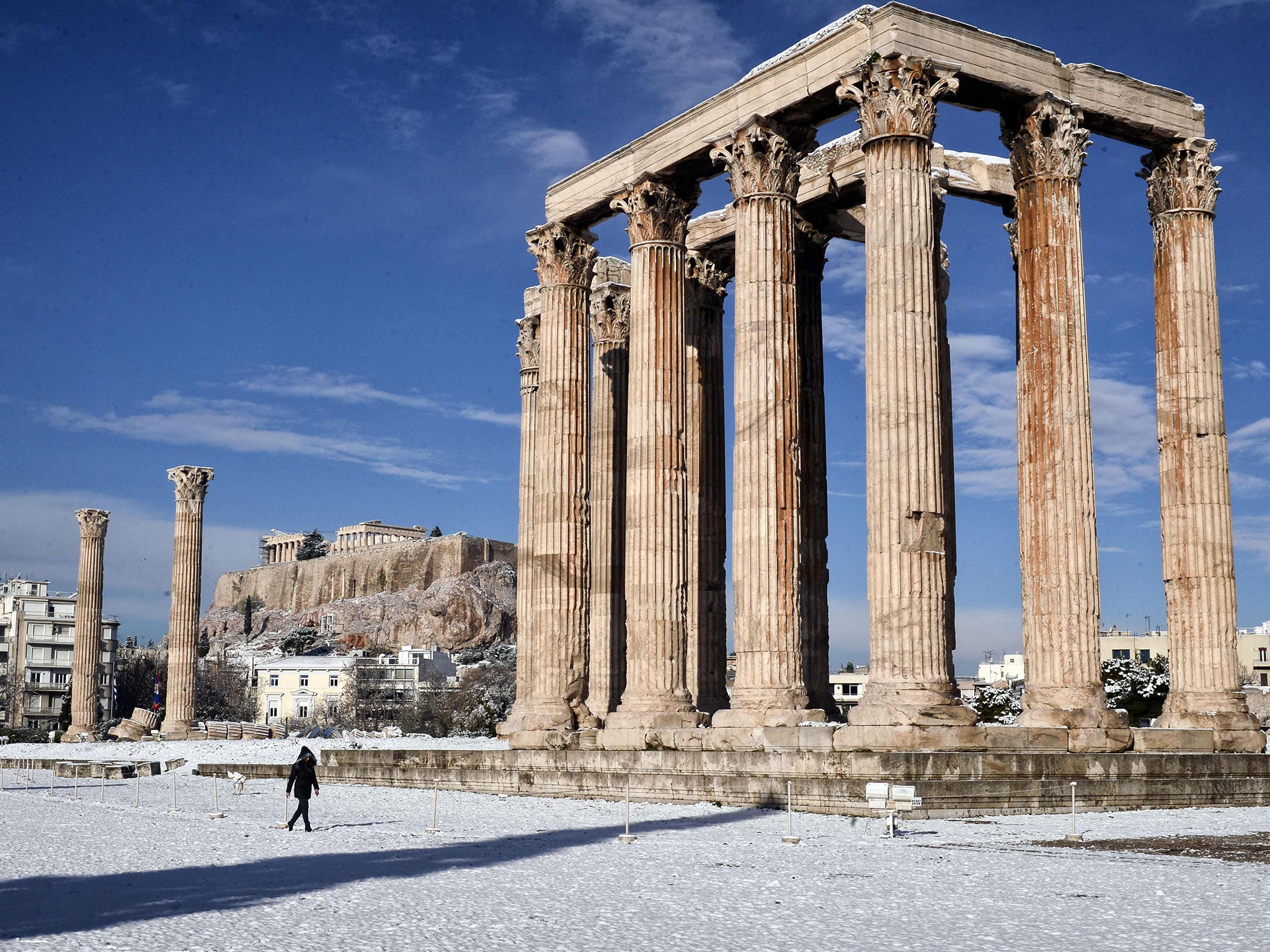 A woman visits the archaeological site of Olympion Zeus in Athens, after rare snowfall on the city, on 10 January