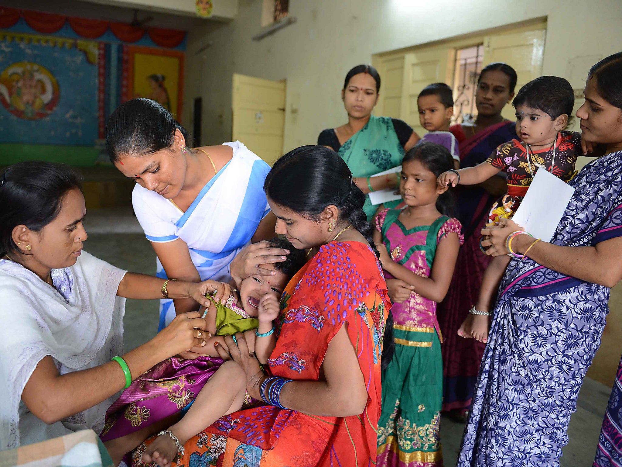 An Indian medical volunteer administers a dose of injectable polio vaccine (IPV) to a child during a vaccination drive in Hyderabad