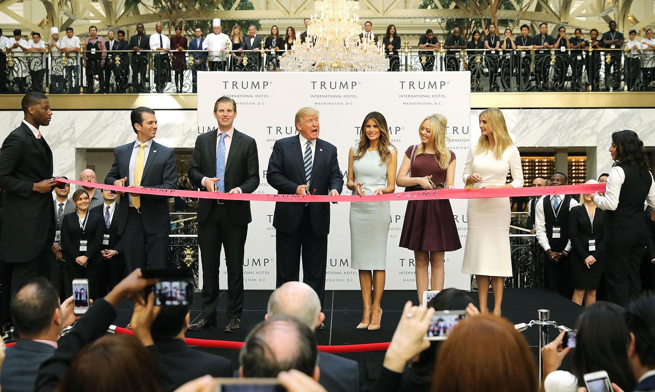 Donald Trump (C) and his family (L-R) son Donald Trump Jr, son Eric Trump, wife Melania Trump and daughters Tiffany Trump and Ivanka Trump cut the ribbon at the new Trump International Hotel October 26, 2016 in Washington, DC.