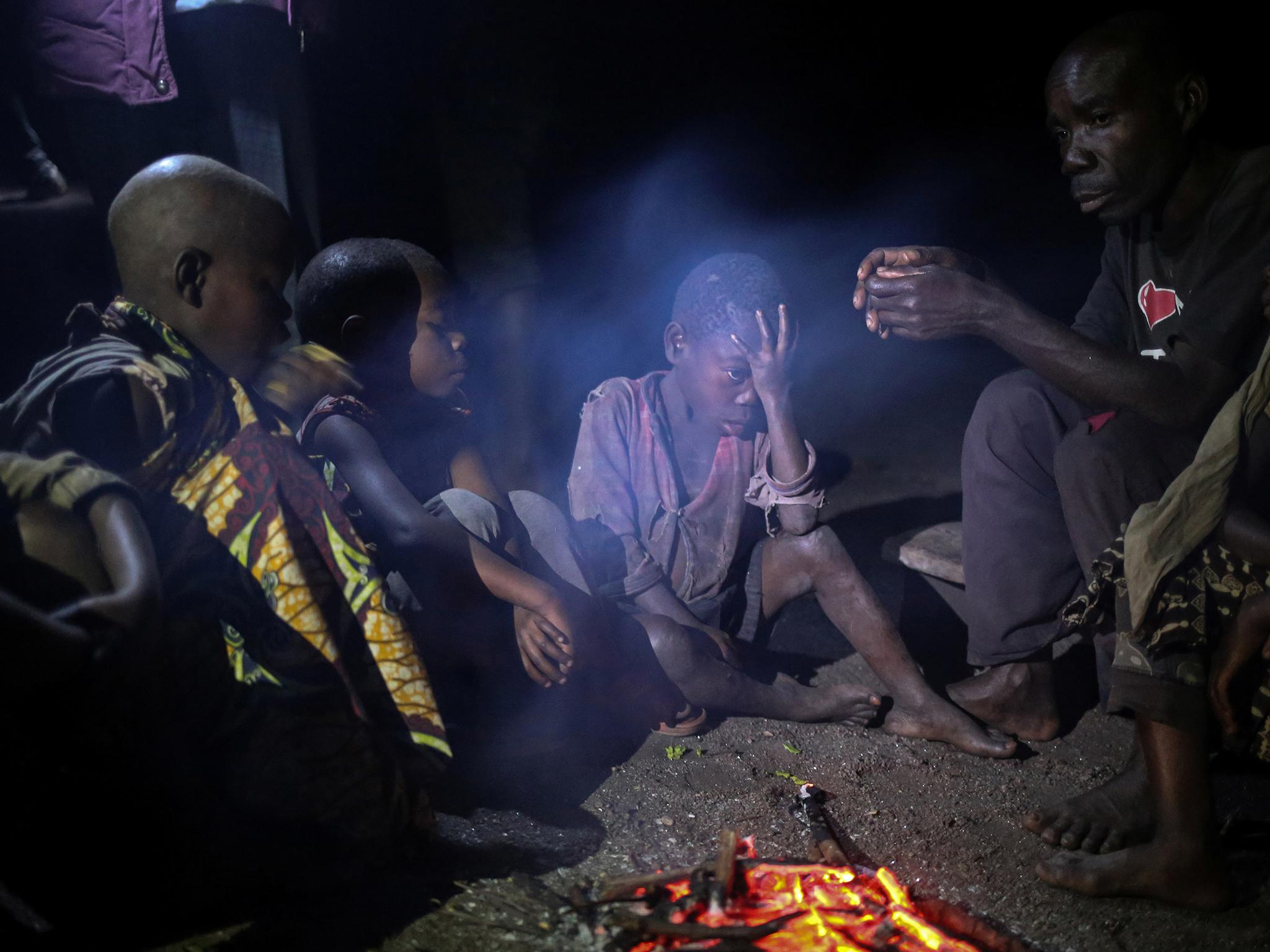 People gather around a fire in Kagorwa pygmy camp