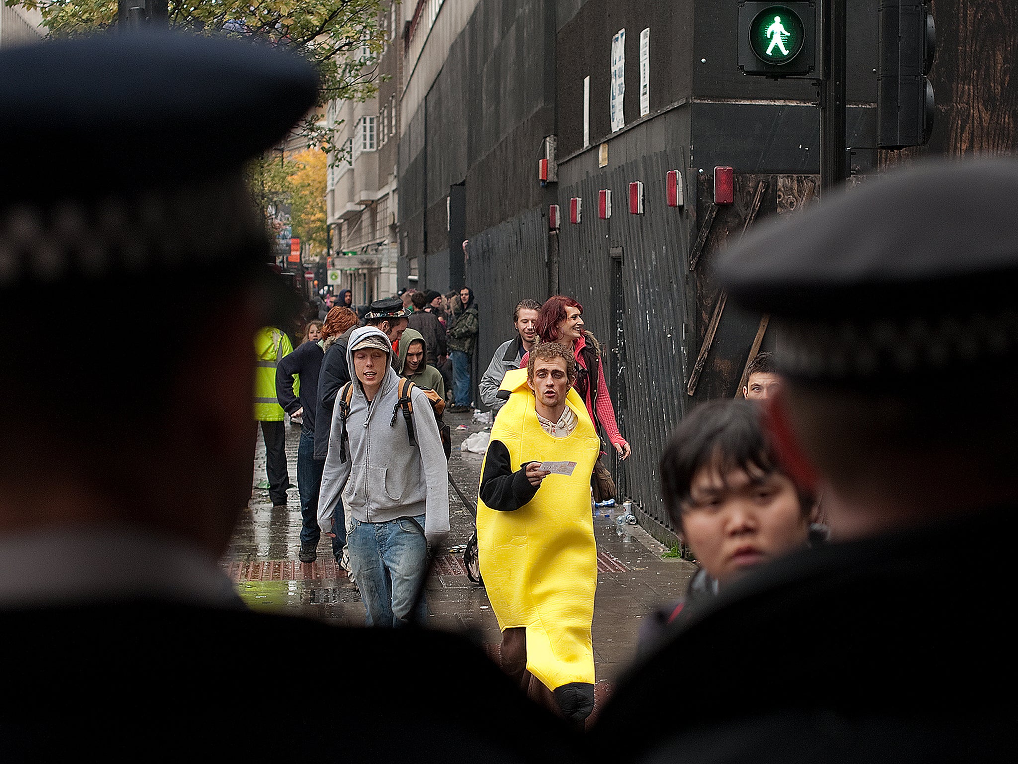 Police officers look on as people leave an alleged illegal rave in an abandoned building in central London. Earlier in the night, three people were taken to hospital with injuries following clashes as police tried to disperse the crowd