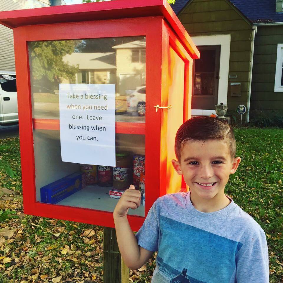 Six-year-old Paxton Burns stands in front of the food pantry he set up with the help of his mother Maggie Ballard