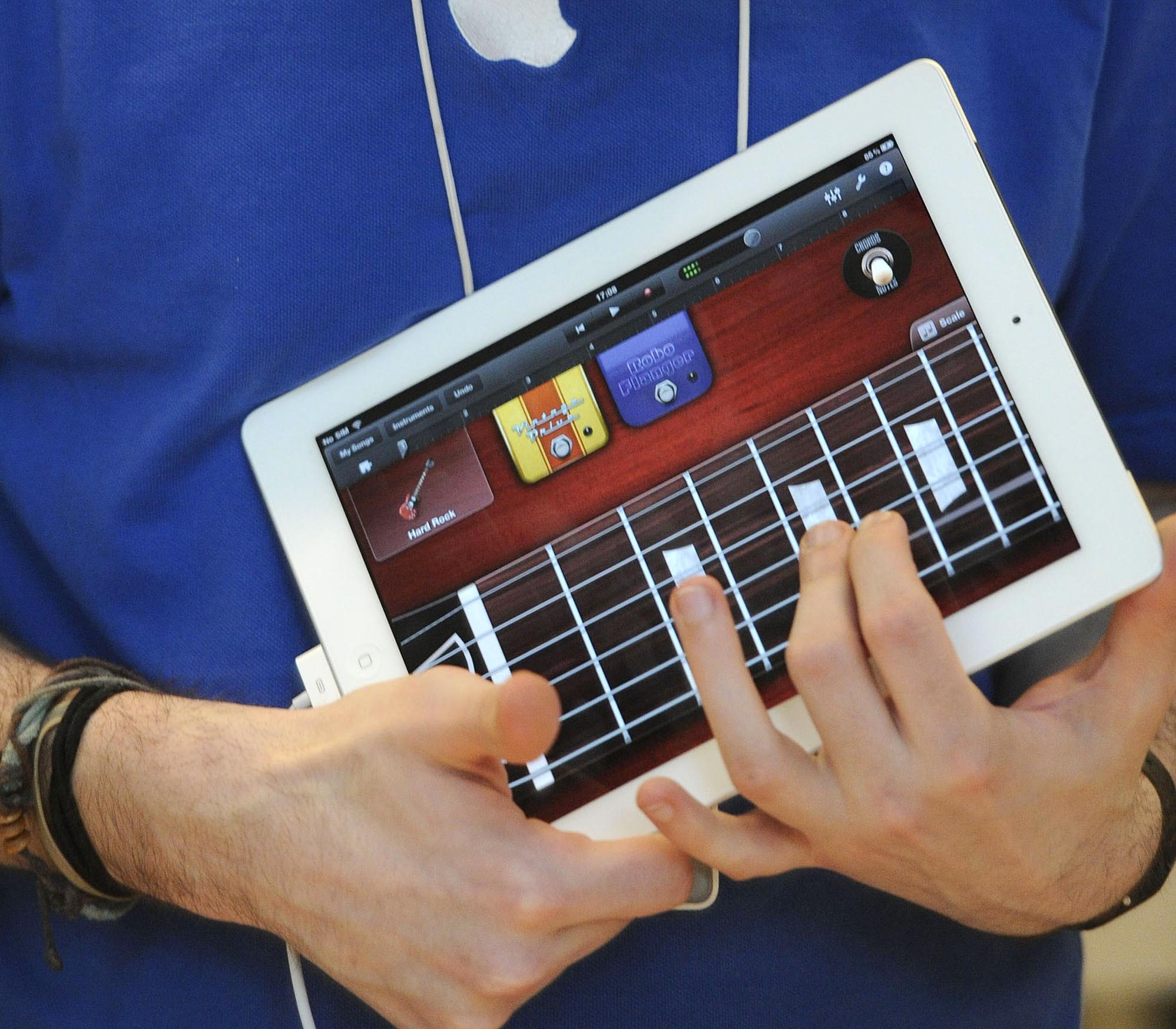 A staff member tries out the GarageBand application on the new iPad 2 at the Apple store in central London, on March 25, 2011