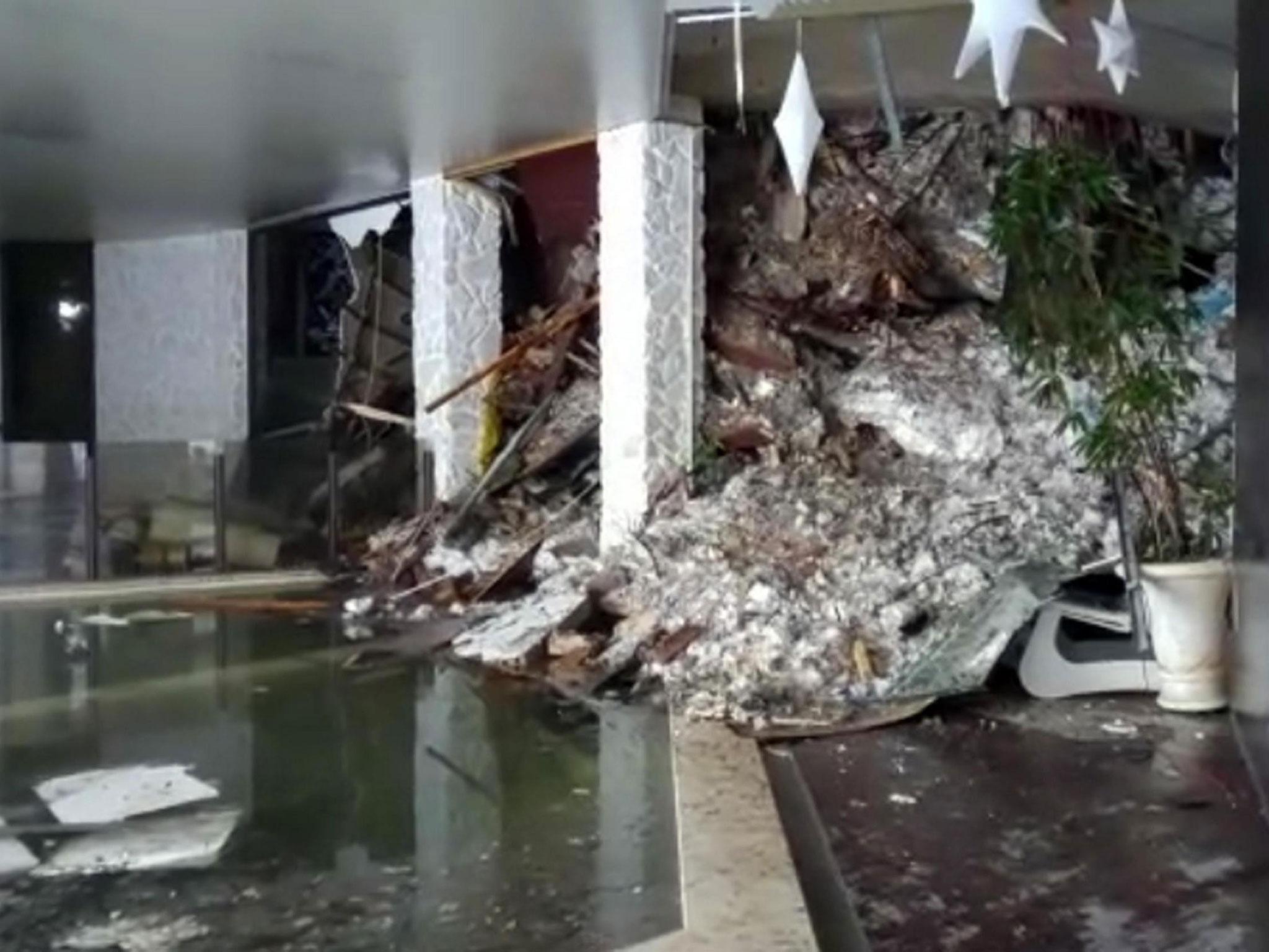 Video shows show piles of snow and rubble cascading down the stairway into the foyer of the hotel