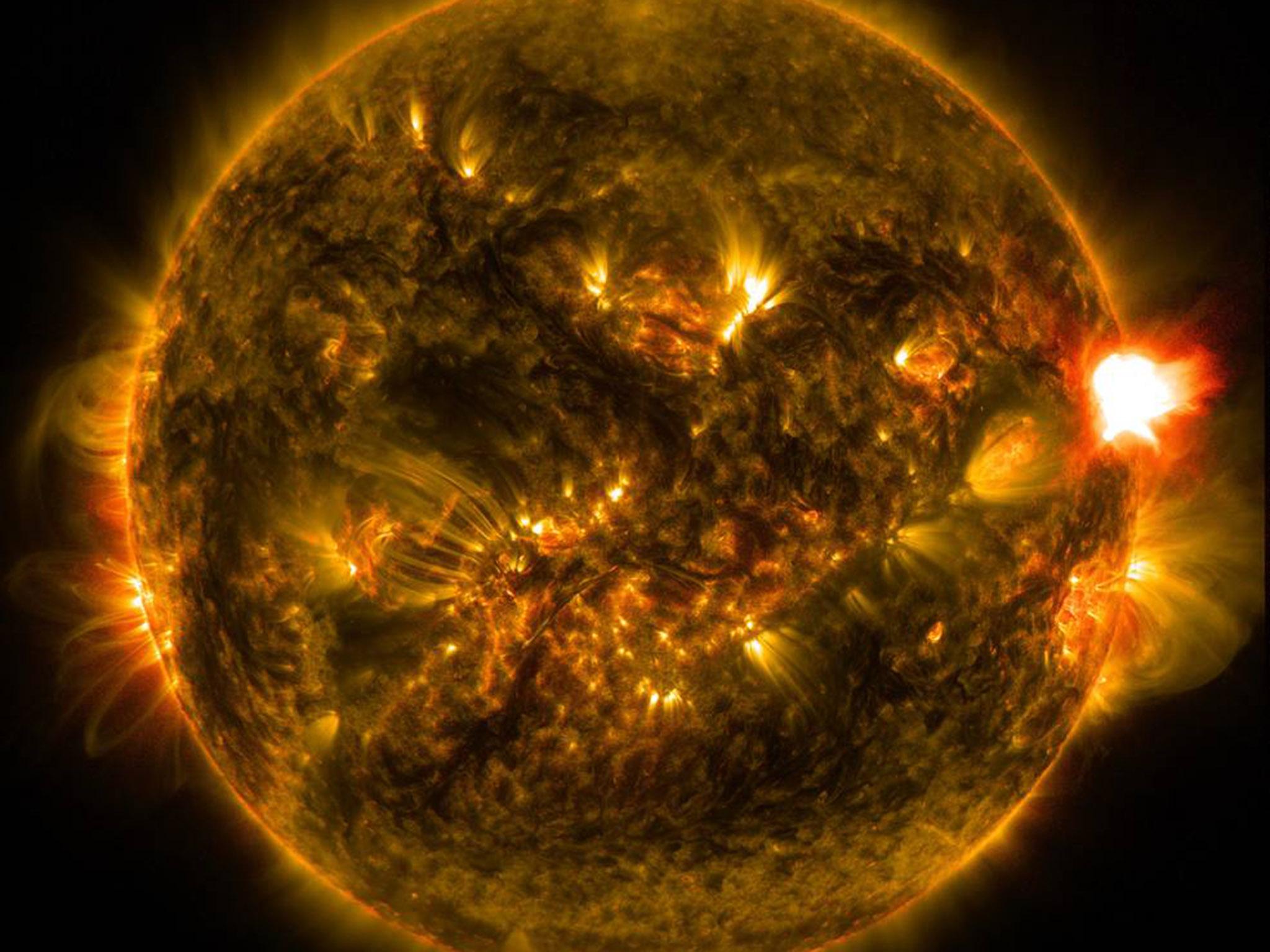 An M-class solar flare erupts from the right side of the sun in this image from shortly before midnight EST on Jan. 12, 2015. The image blends two wavelengths of light -- 171 and 304 angstroms -- as captured by NASA's Solar Dynamics Observatory