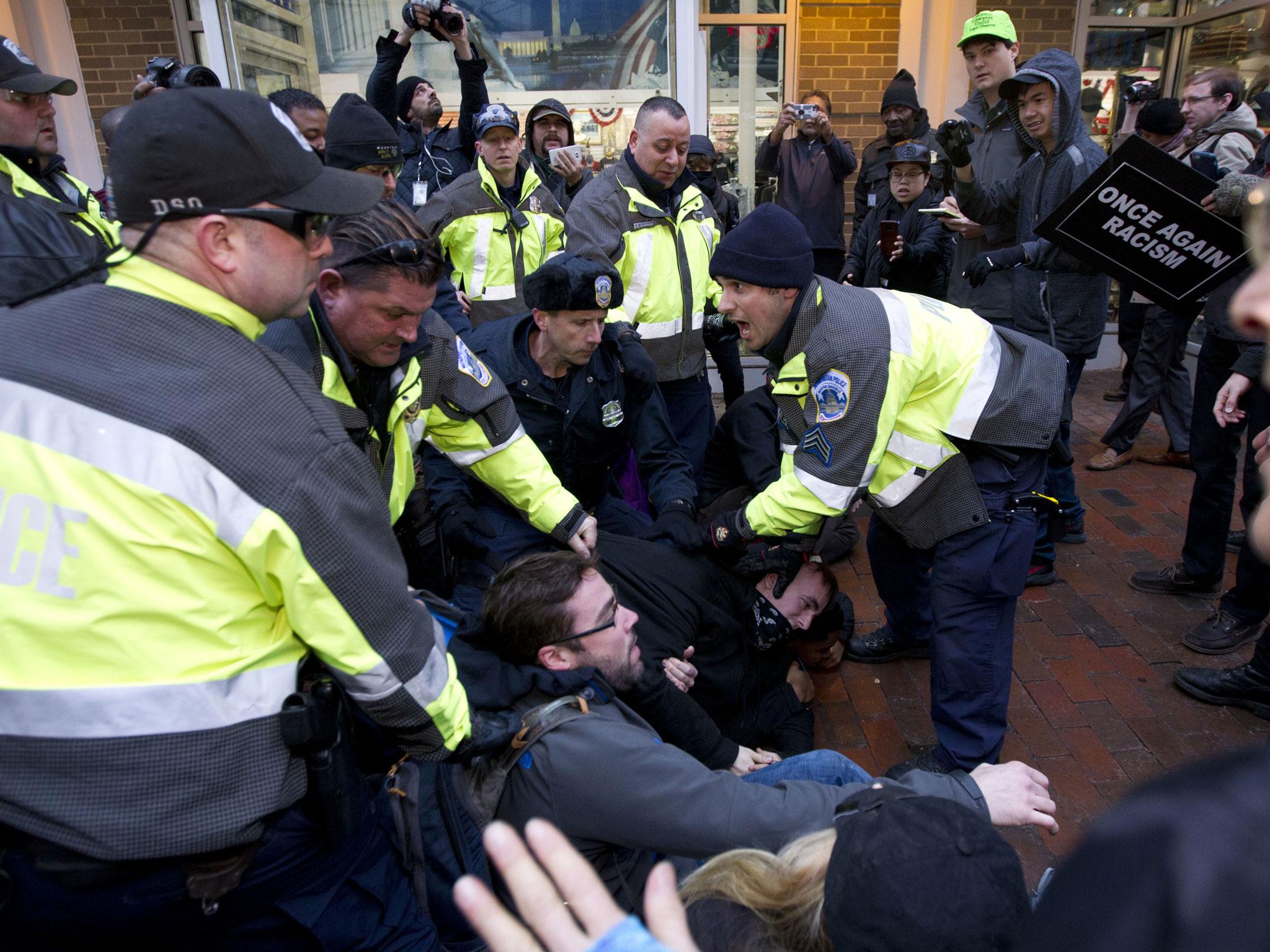 Police try to remove demonstrators from attempting to block people entering a security checkpoint