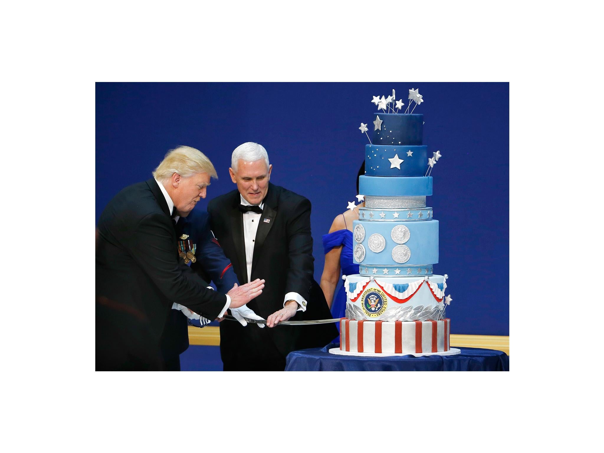 U.S. President Donald Trump and Vice President Mike Pence prepare to cut a cake with a sword at the "Salute to Our Armed Forces" inaugural ball during inauguration festivites in Washington, DC January 20, 2016. REUTERS/Rick Wilking