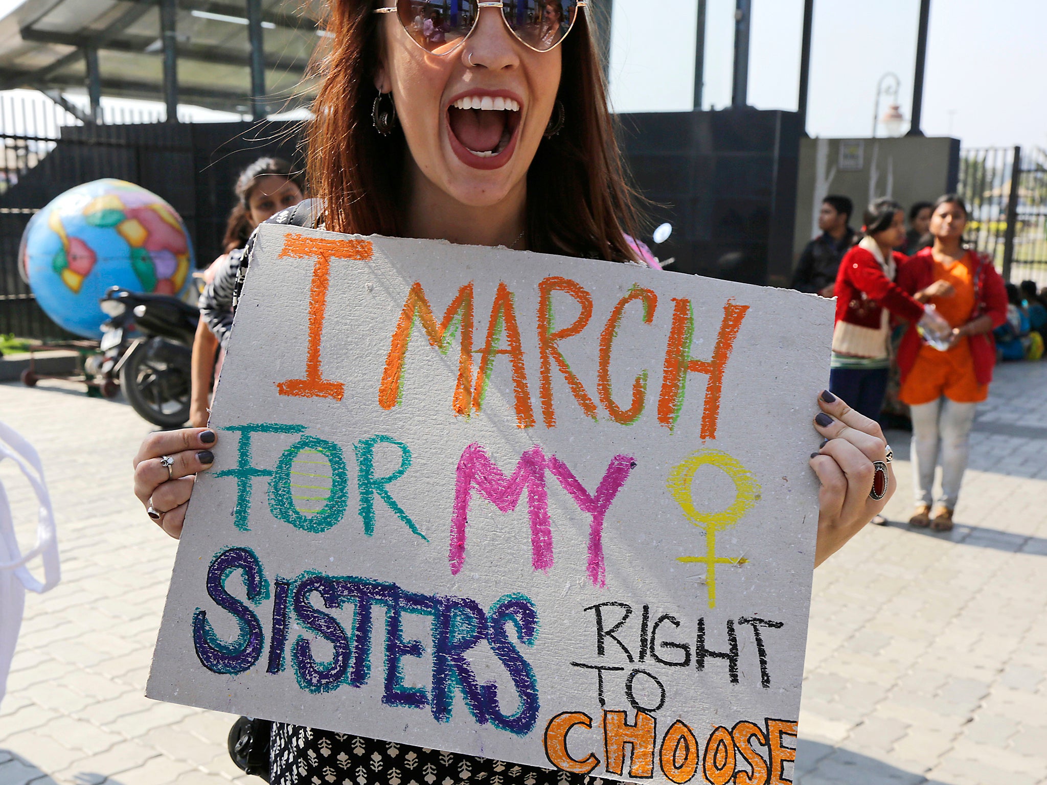 Activist Sarah Annay Williamson holds a placard and shouts slogan during the Women's March rally in Kolkata, India